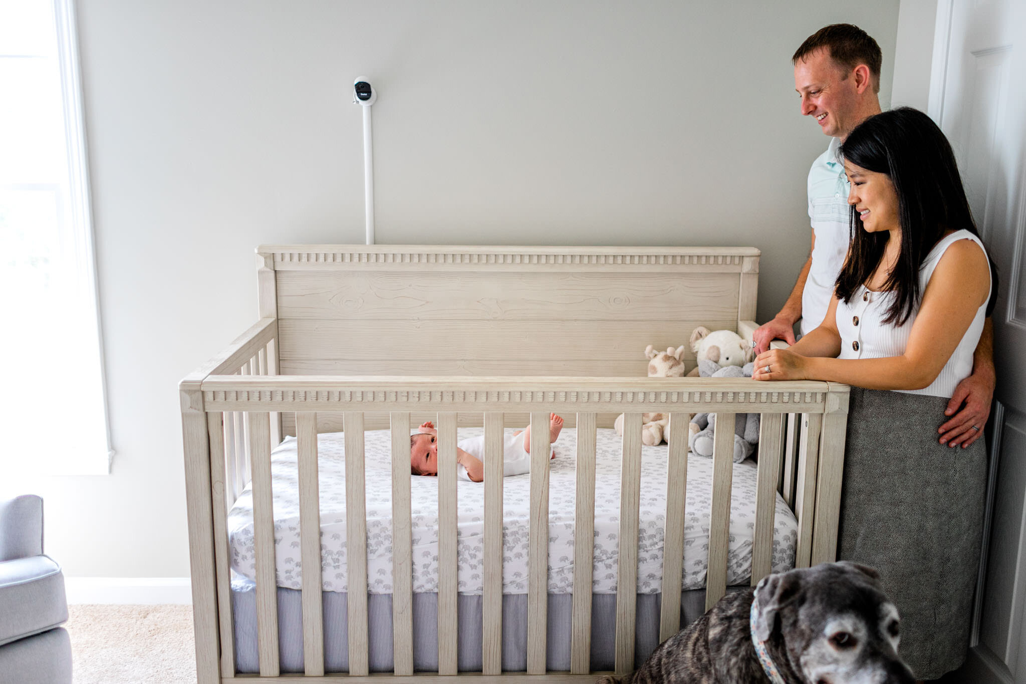 Parents looking at baby in crib | Durham Newborn Photographer | By G. Lin Photography