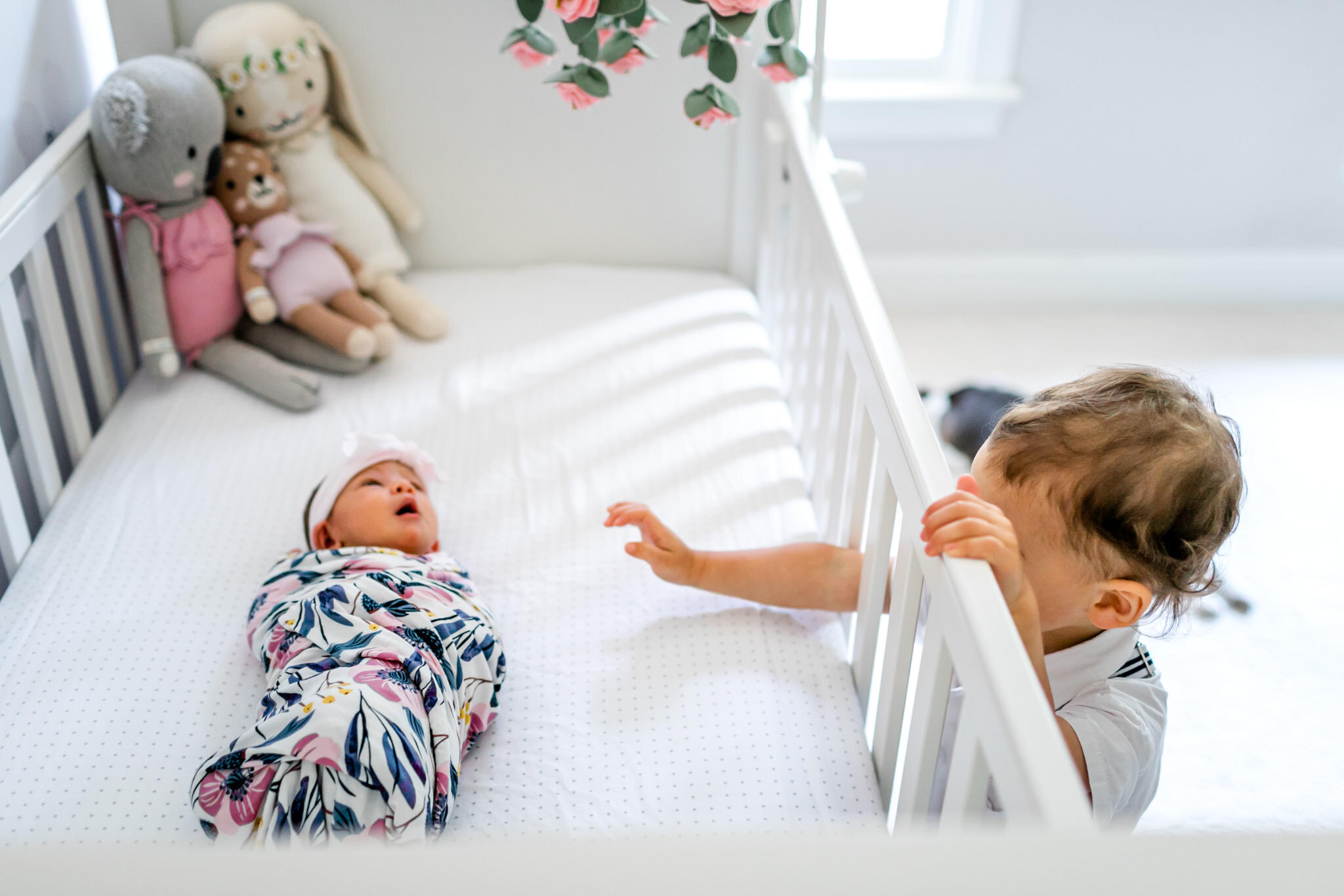 Young toddler boy looking at baby in crib | Durham Newborn Photographer | By G. Lin Photography