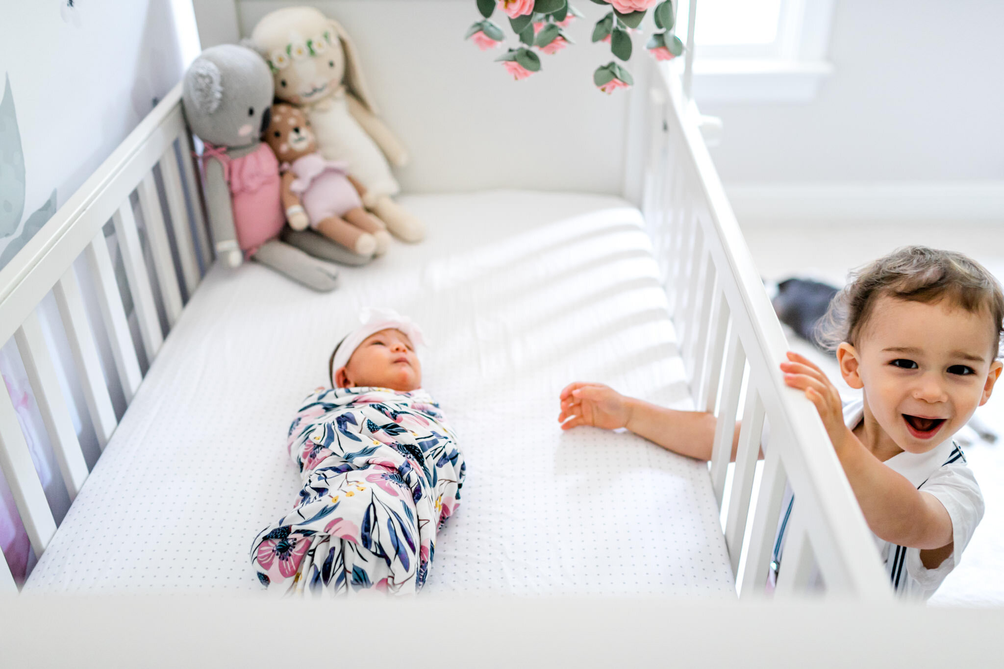 Toddler boy standing next to white crib | Durham Newborn Photographer | By G. Lin Photography