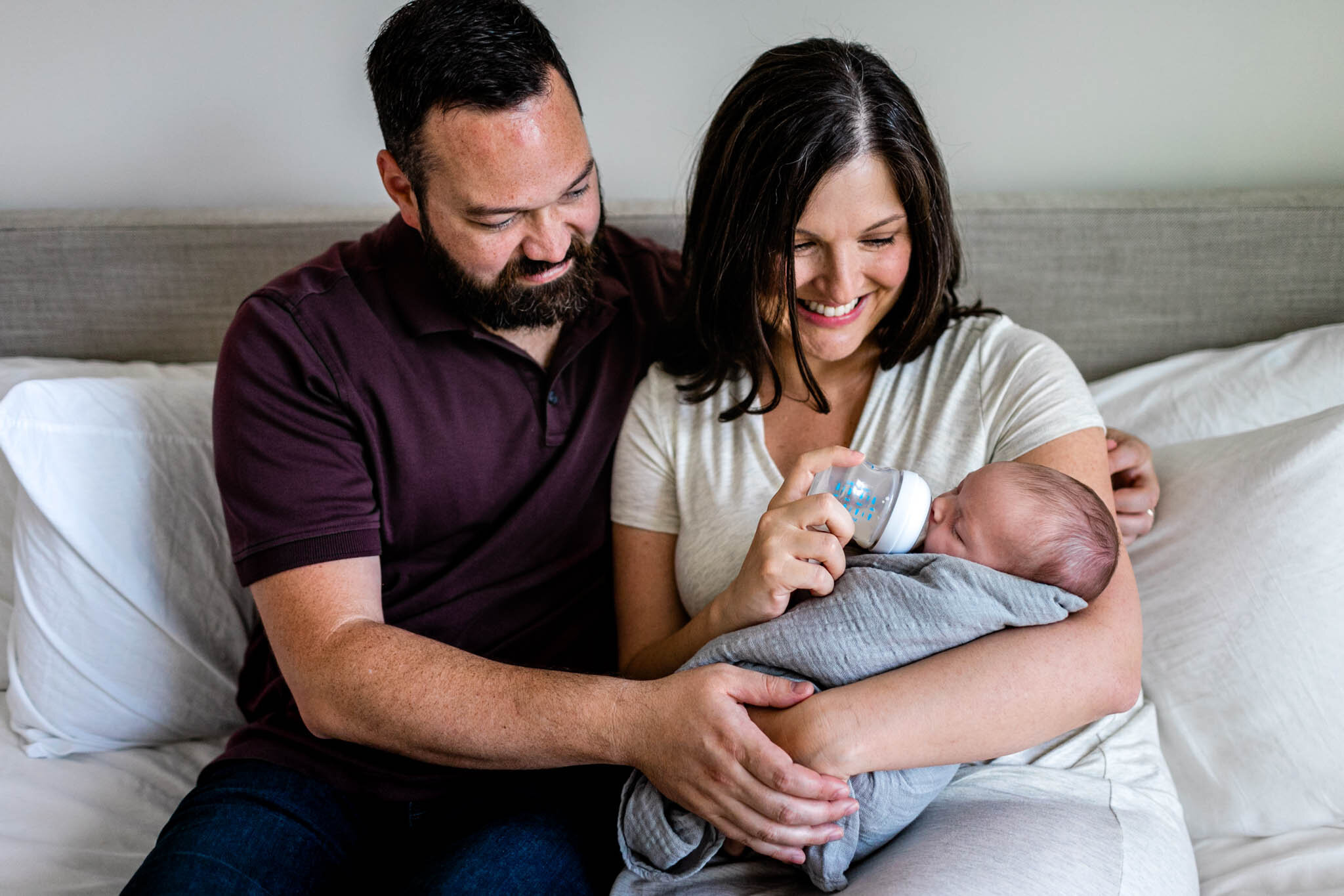 Parents holding baby and feeding her a bottle | Durham Newborn Photographer | By G. Lin Photography