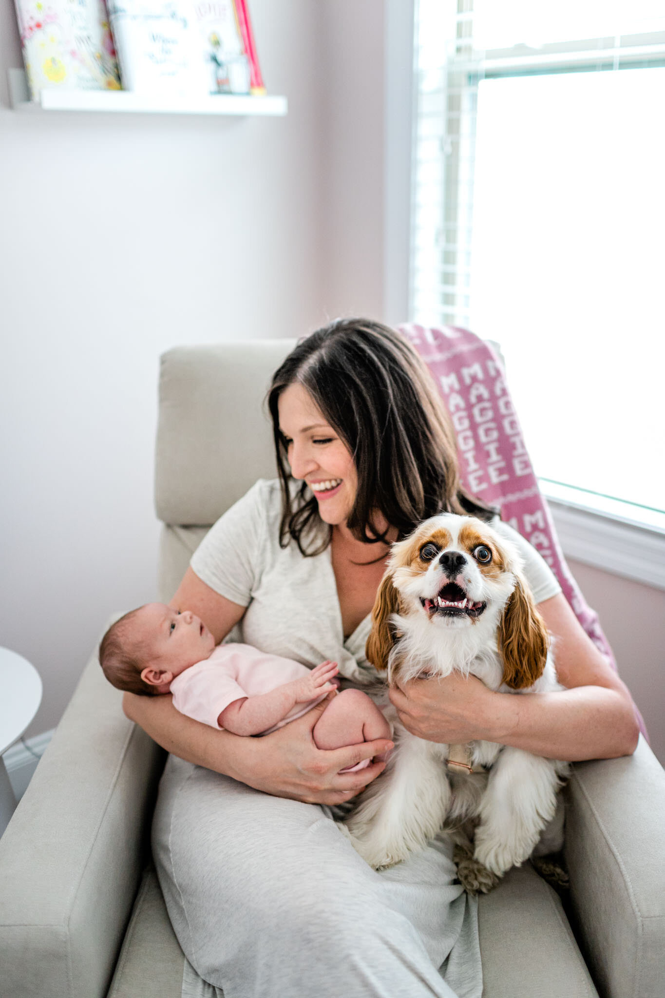 Durham Newborn Photographer | By G. Lin Photography | Woman holding dog and baby in nursery