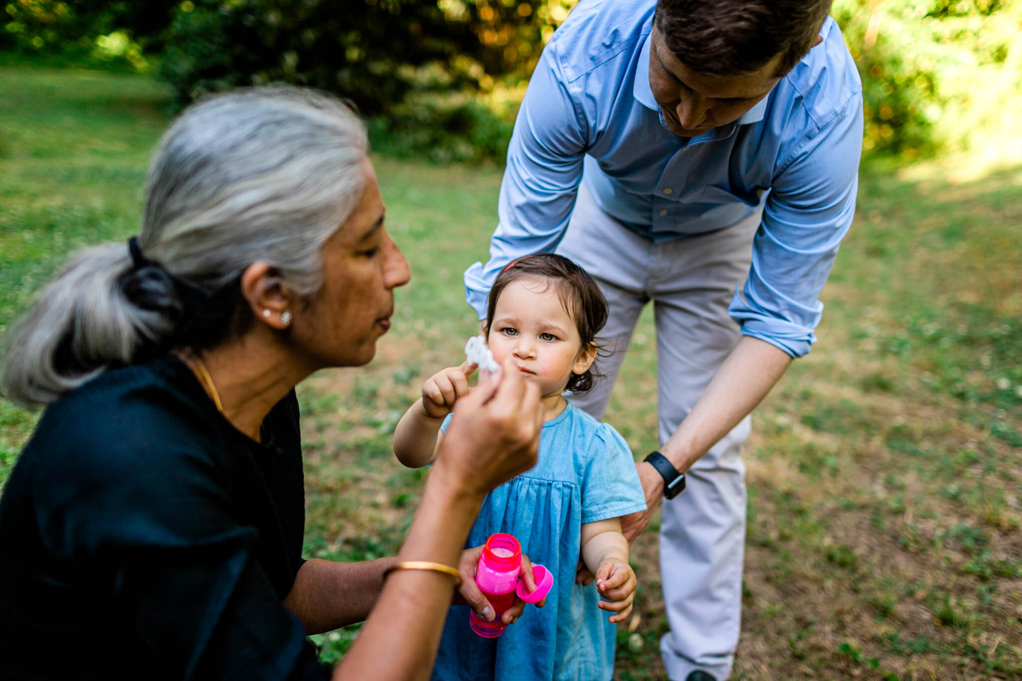 Grandmother blowing bubbles | Forest Hills Park | Durham Family Photographer | By G. Lin Photography
