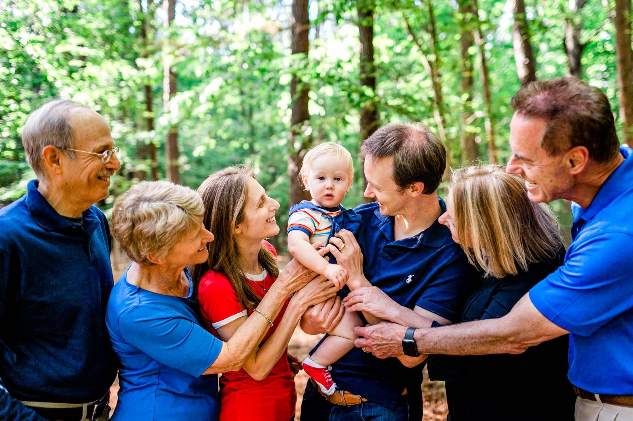 Raleigh Family Photographer | Umstead Park | By G. Lin Photography | Family holding baby and smiling