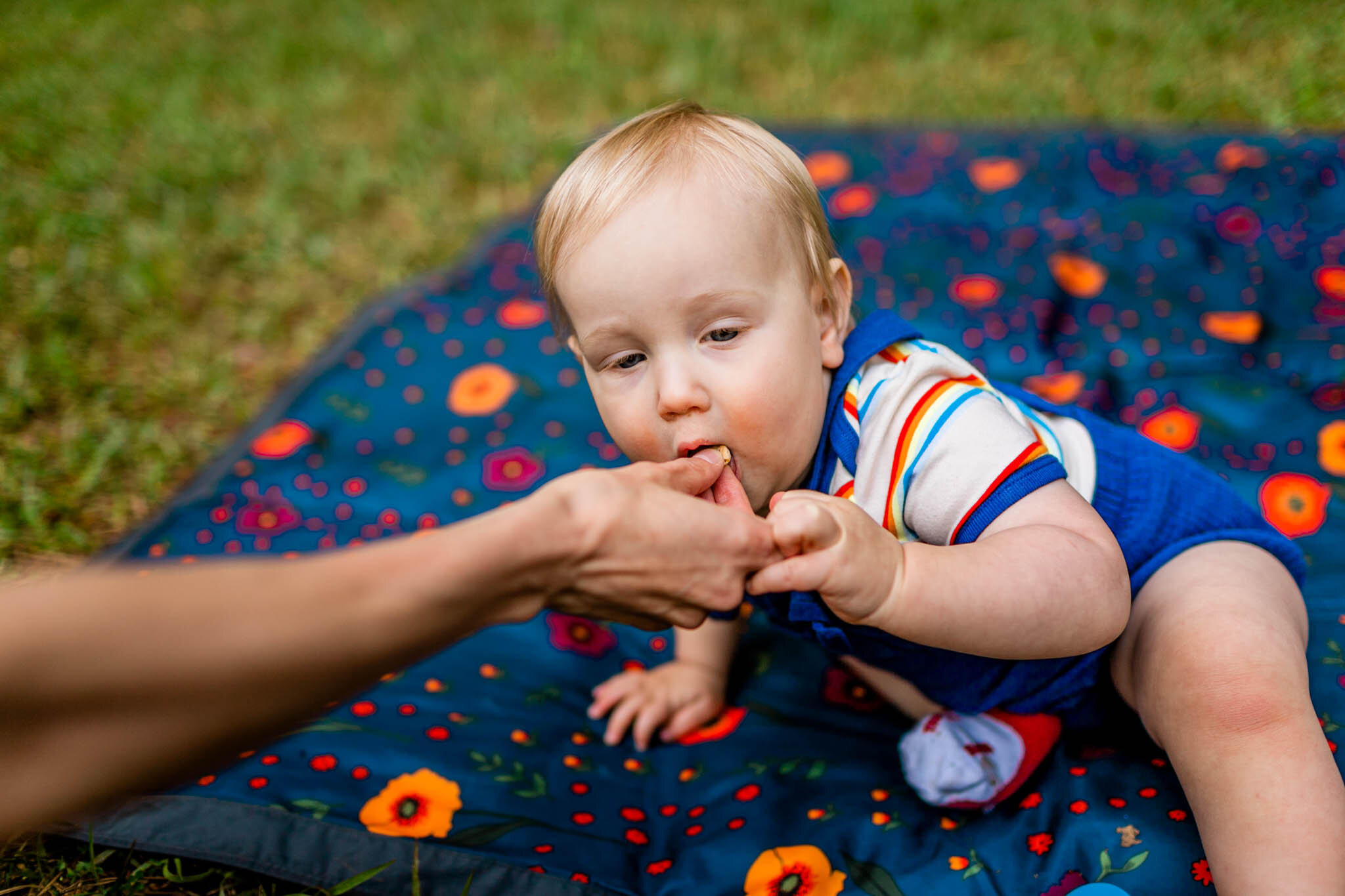 Raleigh Family Photographer | Umstead Park | By G. Lin Photography | Baby boy eating Cheerio from mom