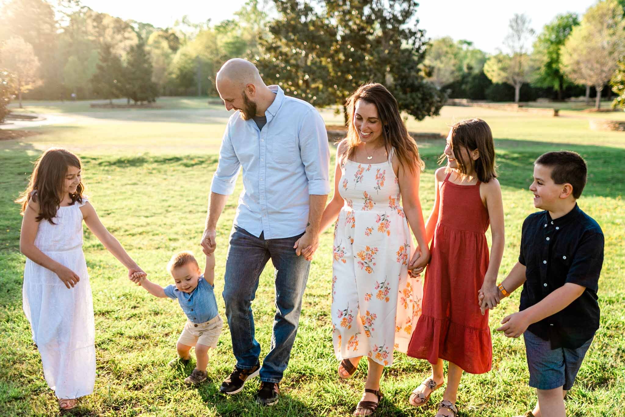Raleigh Family Photographer | Joyner Park | By G. Lin Photography | Family holding hands and walking together