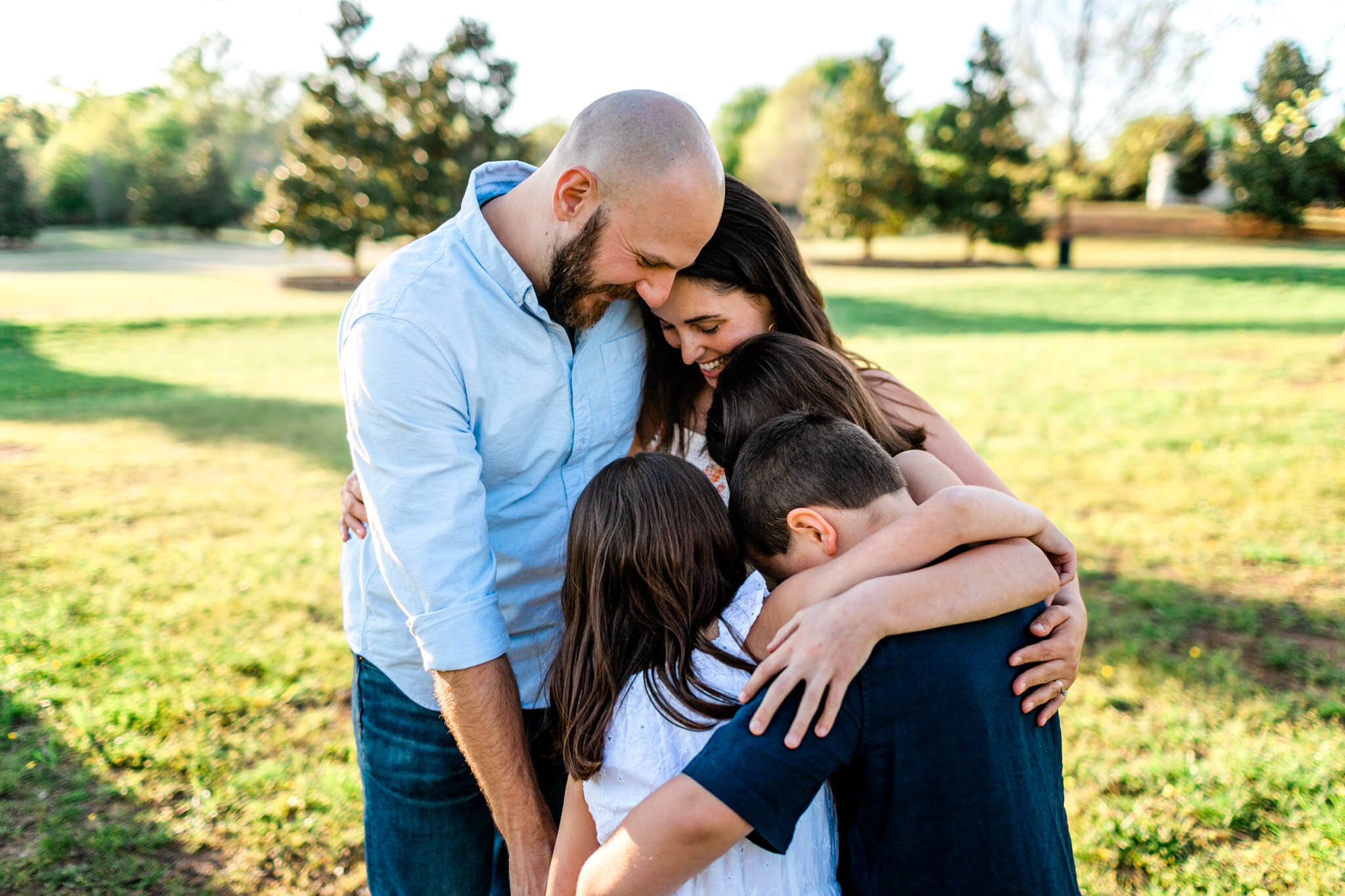 Raleigh Family Photographer | Joyner Park | By G. Lin Photography | Family hugging and holding one another