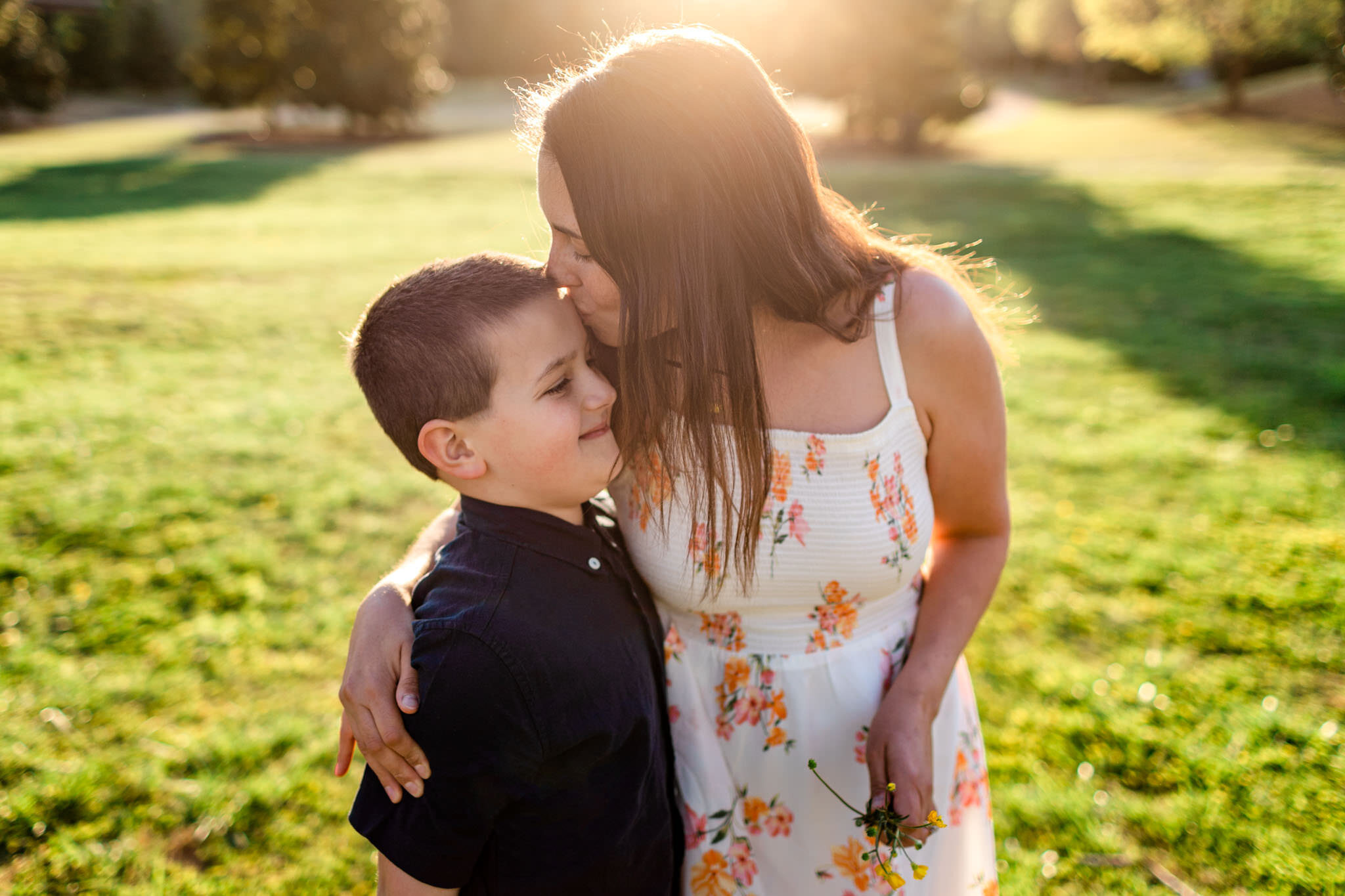 Mom giving a kiss to son | Raleigh Family Photographer | Joyner Park | By G. Lin Photography