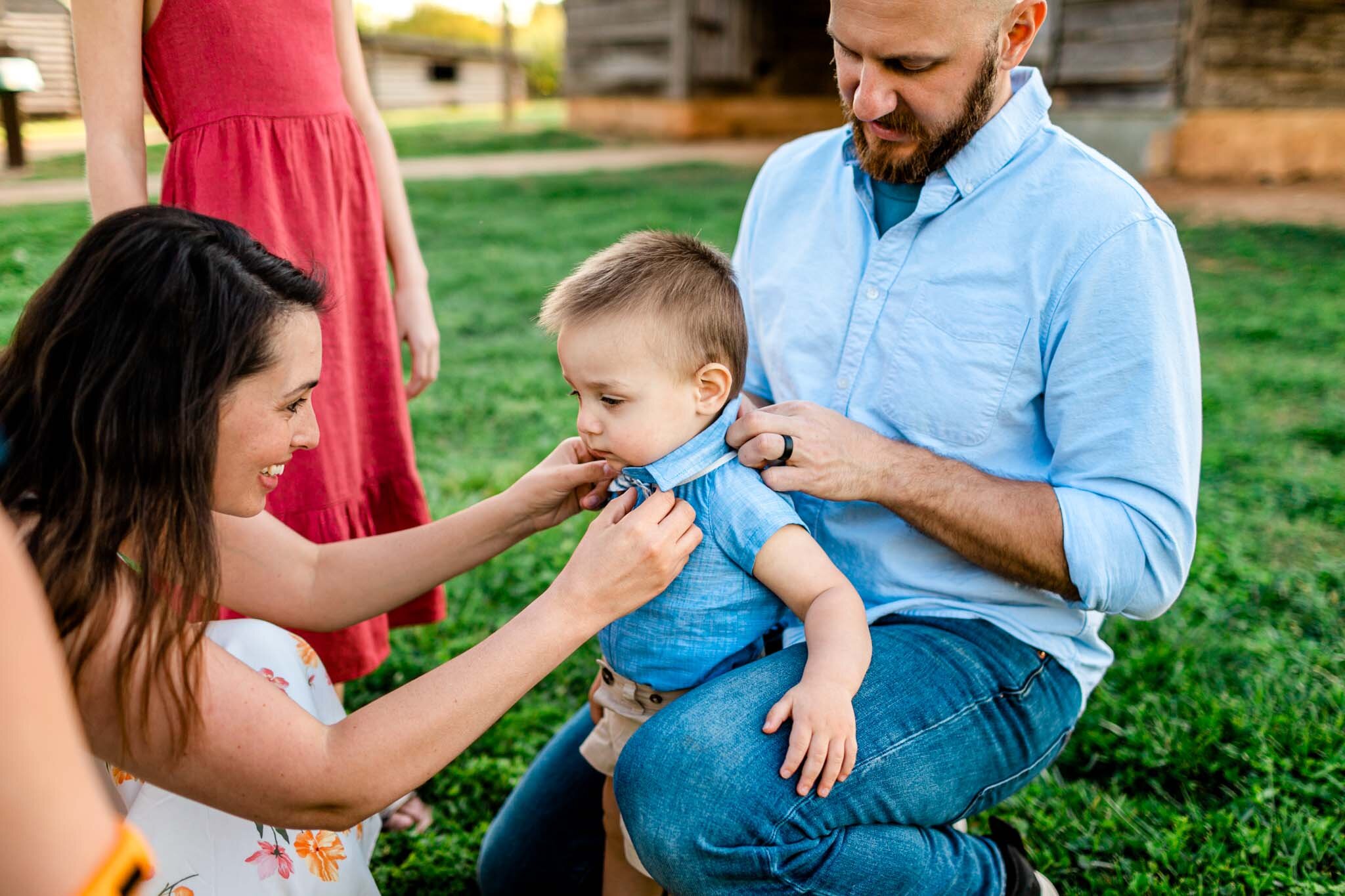 Raleigh Family Photographer | Joyner Park | By G. Lin Photography | Parents helping toddler with clothing