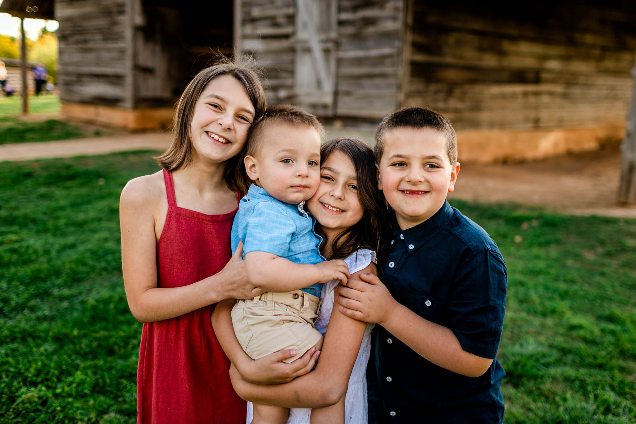 Four children hugging one another and smiling | Raleigh Family Photographer | Joyner Park | By G. Lin Photography