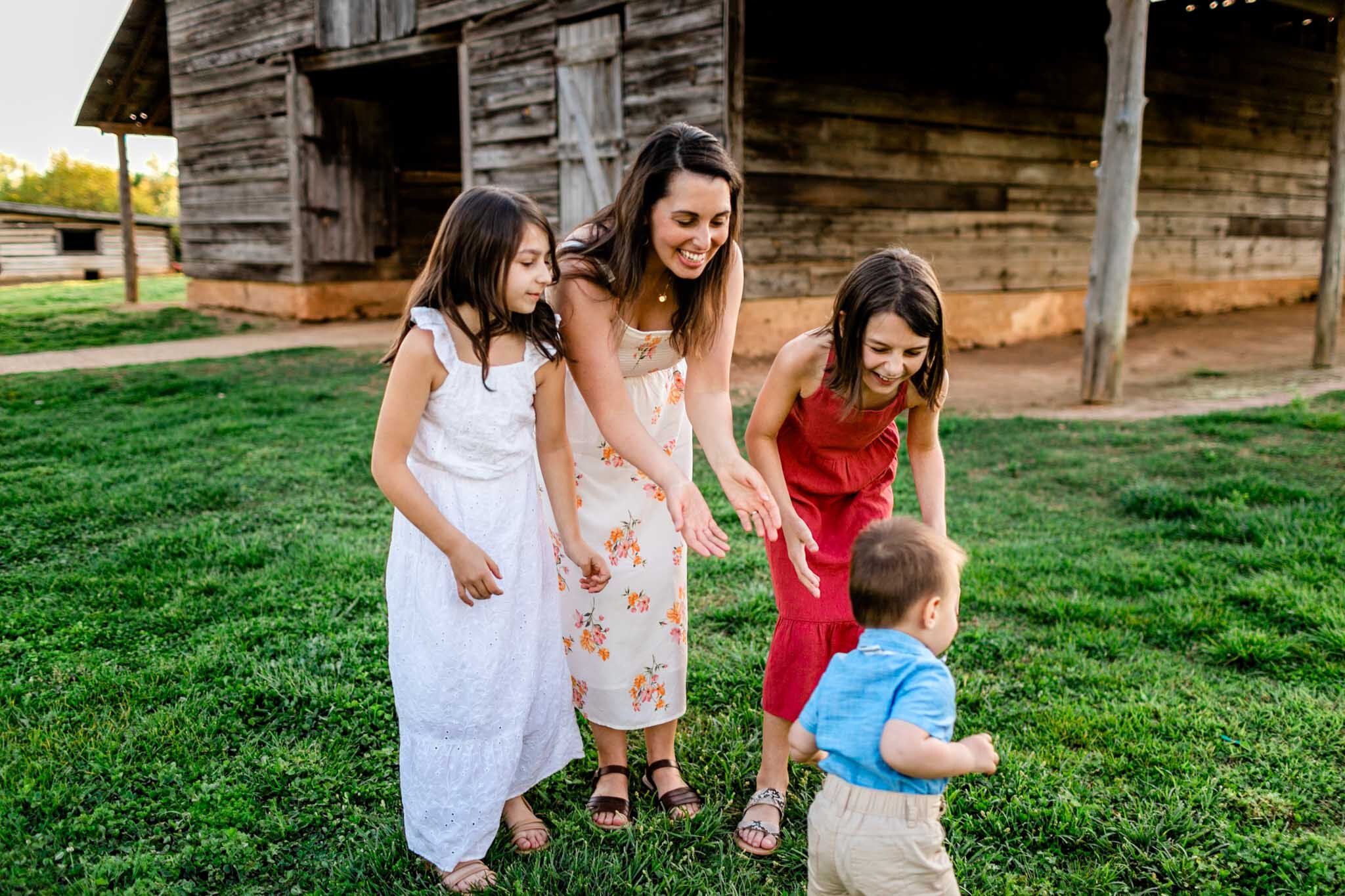 Mom and daughters holding hands out to youngest brother | Raleigh Family Photographer | Joyner Park | By G. Lin Photography