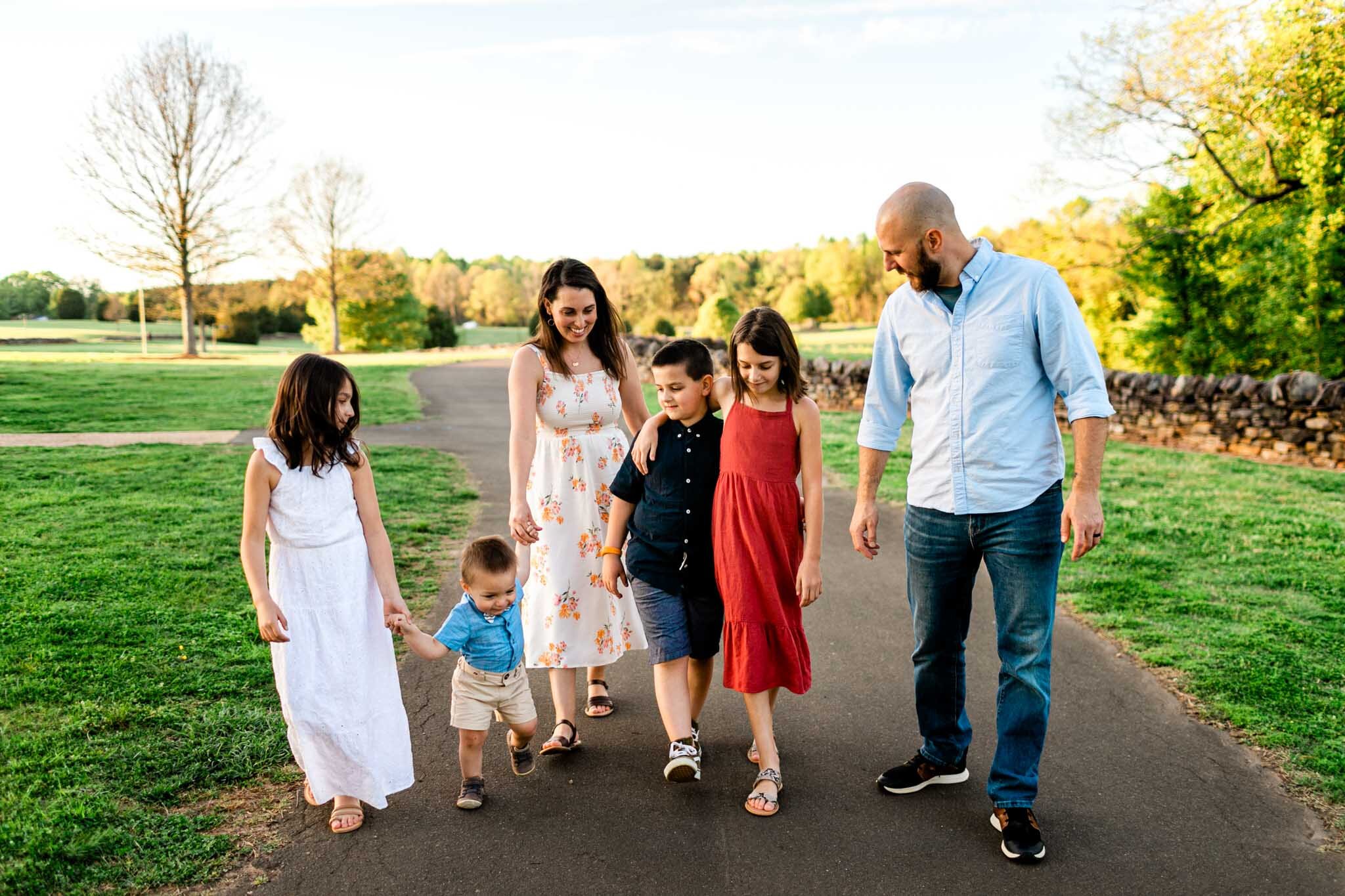 Raleigh Family Photographer | Joyner Park | By G. Lin Photography | Family of six walking together outside on paved path