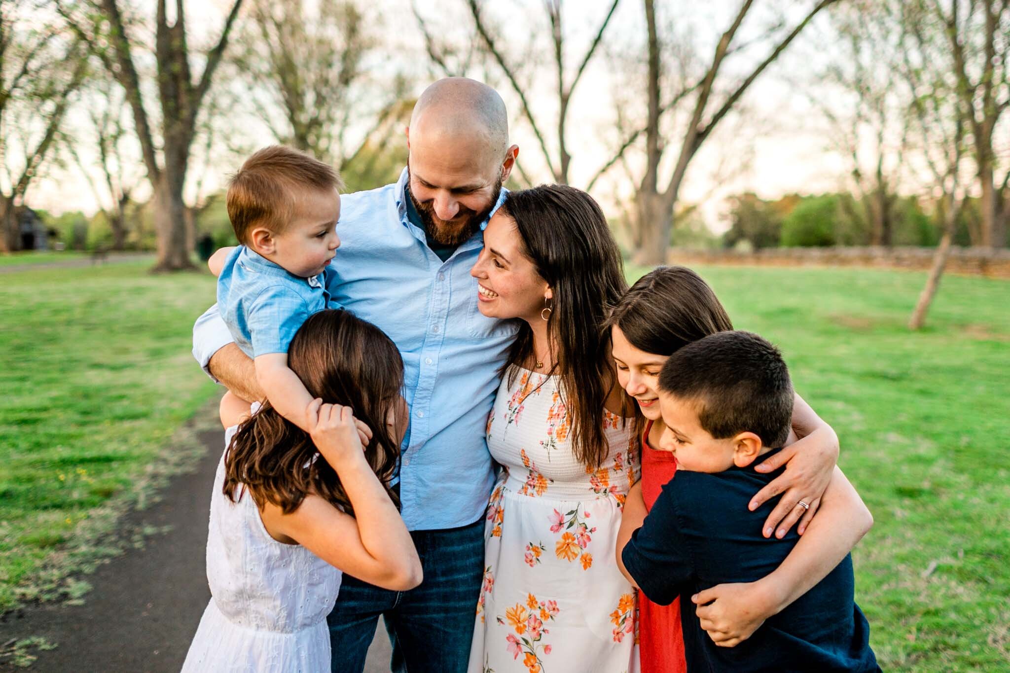 Family hugging one another outside during sunset | Raleigh Family Photographer | Joyner Park | By G. Lin Photography