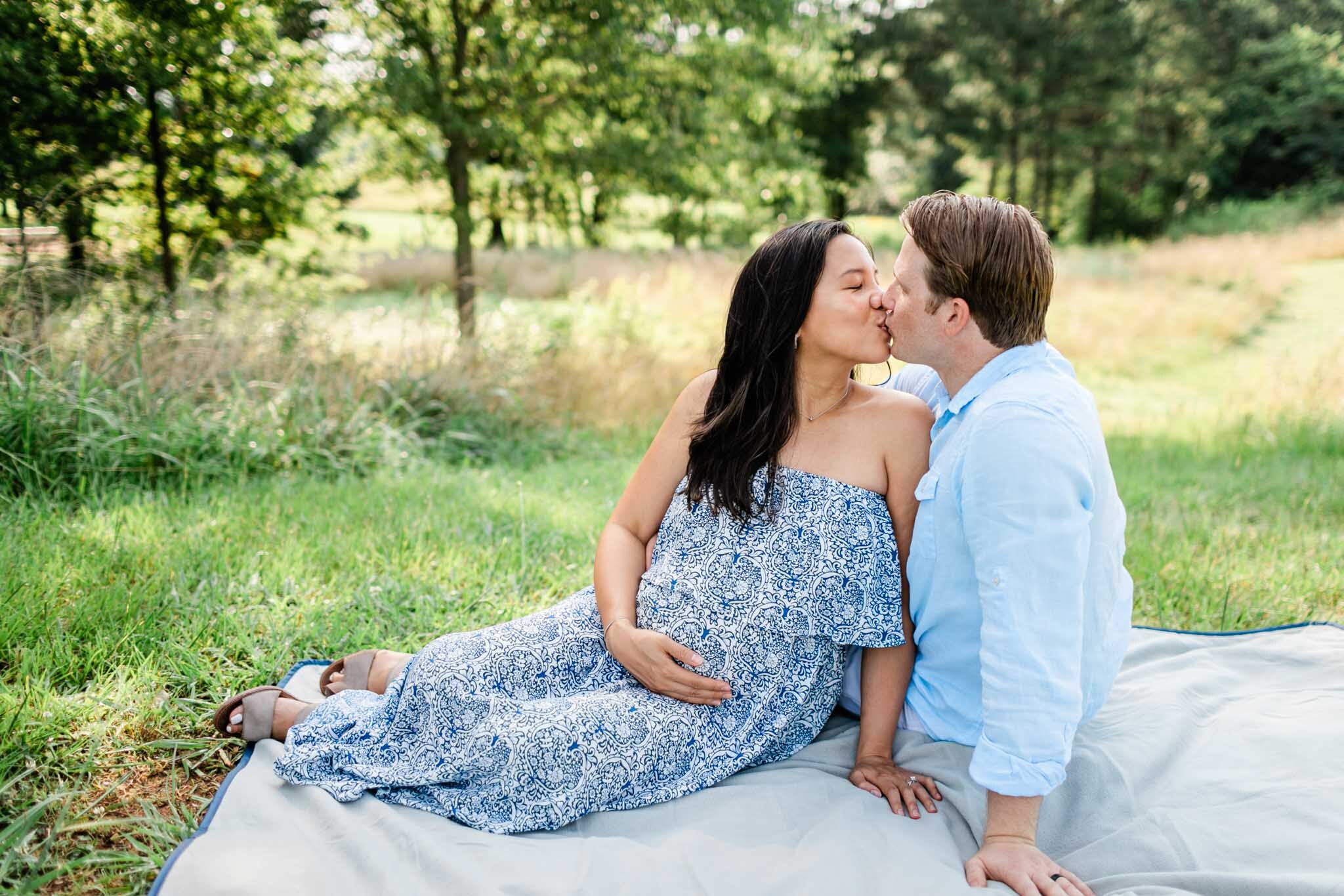Raleigh Maternity Photographer | By G. Lin Photography | NCMA Maternity Photos | Woman and man sitting down on blanket and kissing