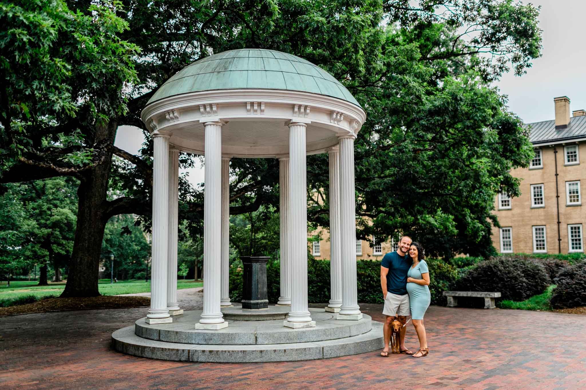 UNC Chapel Hill Maternity Photography | By G. Lin Photography | Woman and man with dog standing by the Old Well