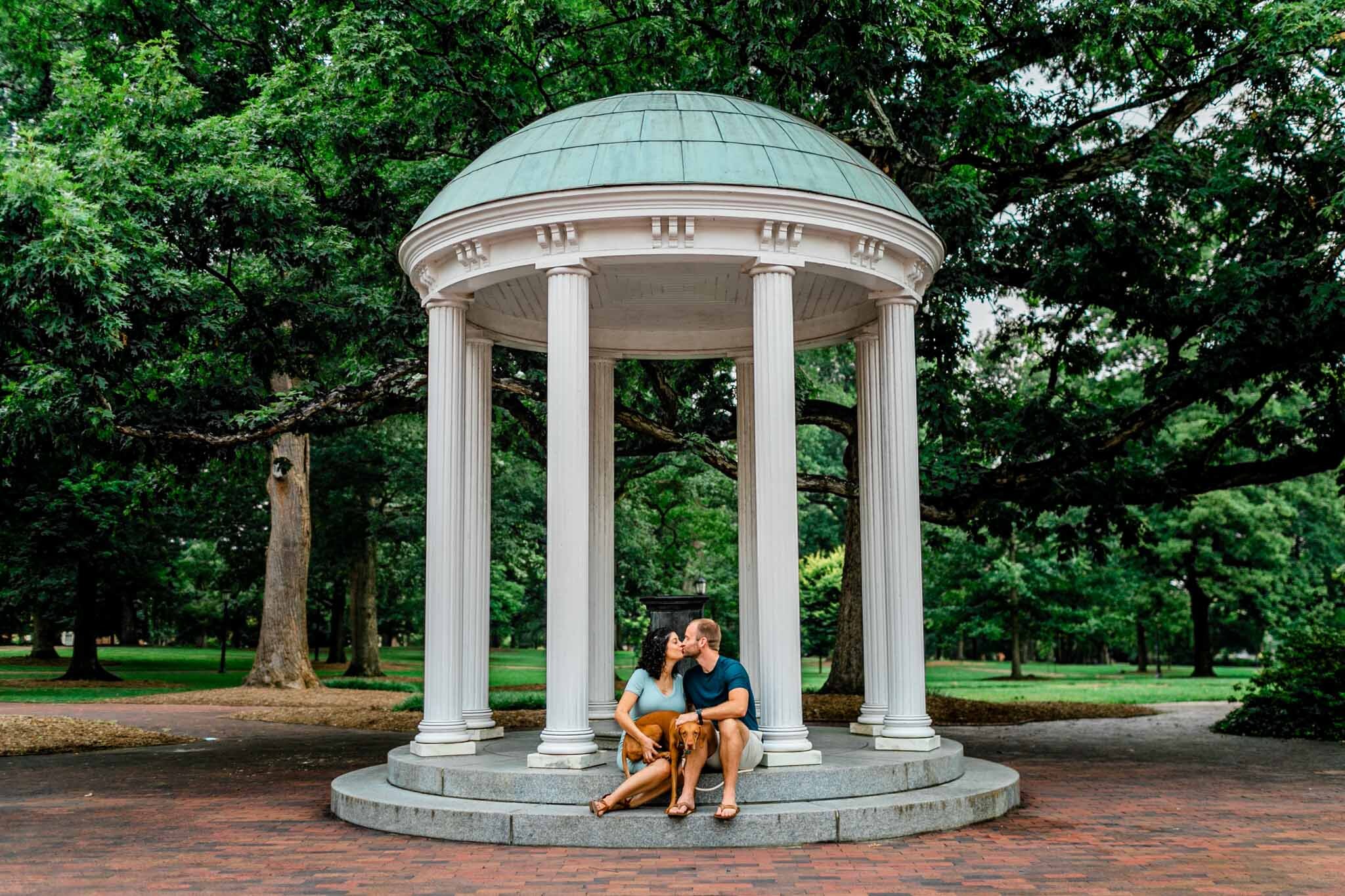 UNC Chapel Hill Maternity Photography | By G. Lin Photography | Couple with dog sitting by the Old Well