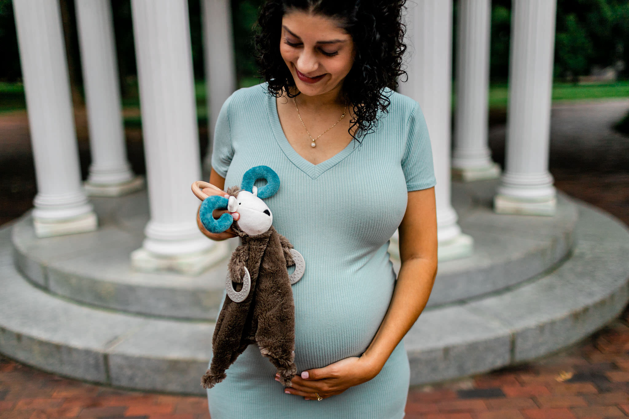 UNC Chapel Hill Maternity Photography | By G. Lin Photography | Woman holding ram doll by Old Well