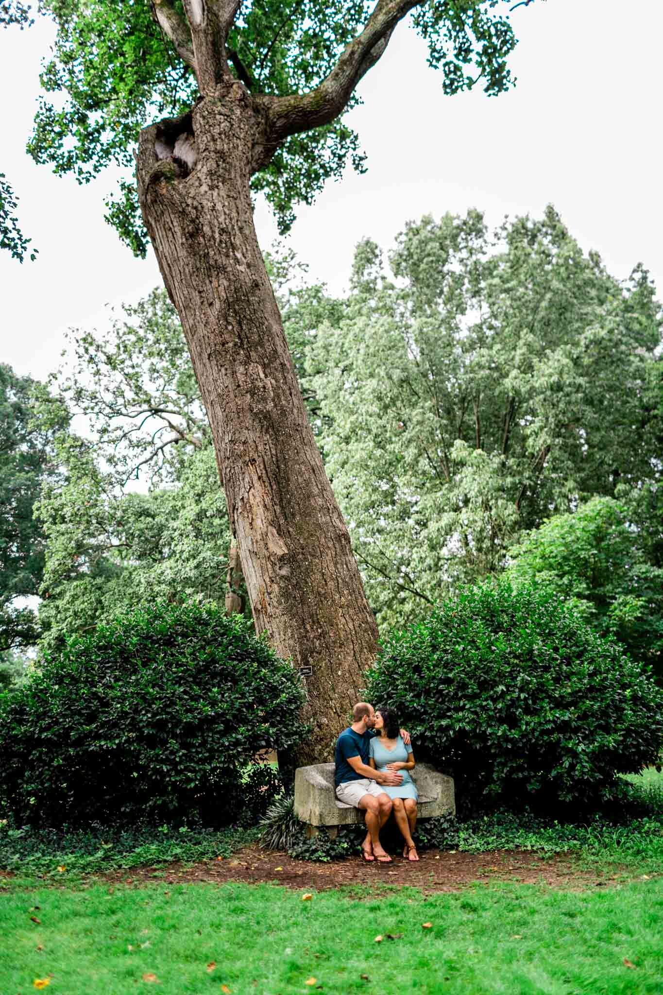 UNC Chapel Hill Maternity Photography | By G. Lin Photography | Couple kissing at Davie Bench