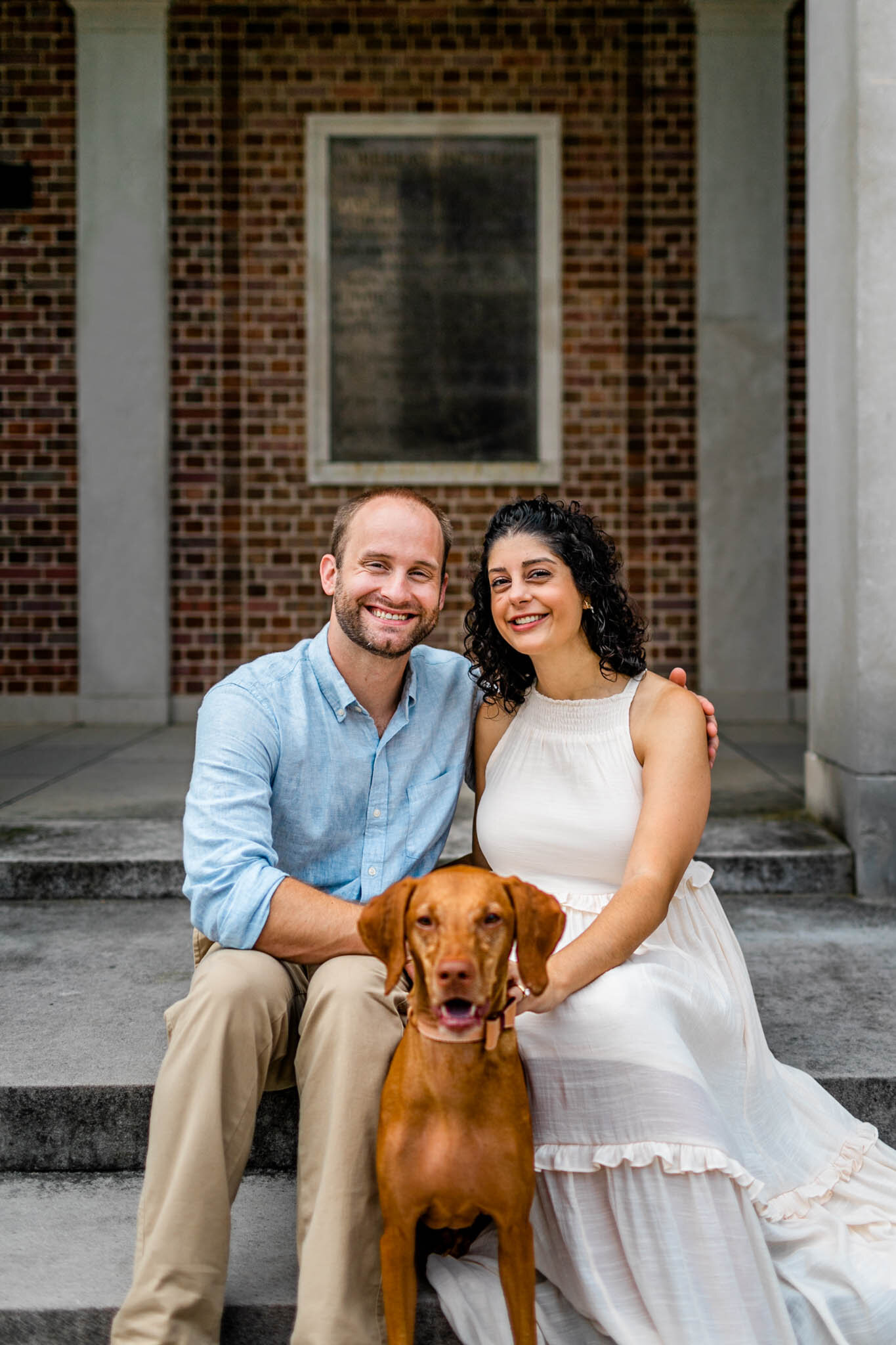 UNC Chapel Hill Maternity Photography | By G. Lin Photography | Couple and dog sitting by the UNC Bell Tower