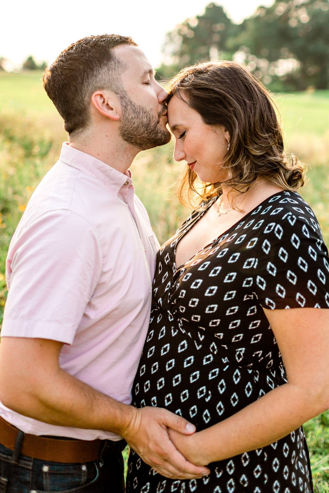 Raleigh Maternity Photographer | By G. Lin Photography | NC Museum of Art | Man kissing woman in open field during sunset