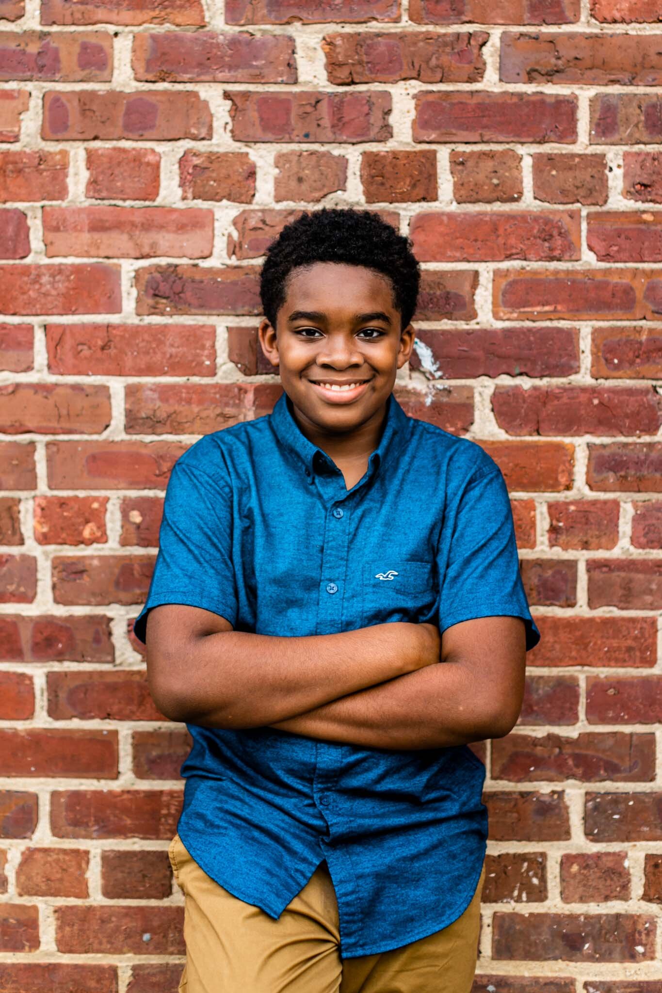 Durham Family Photographer | By G. Lin Photography | Portrait of young boy leaning against brick wall