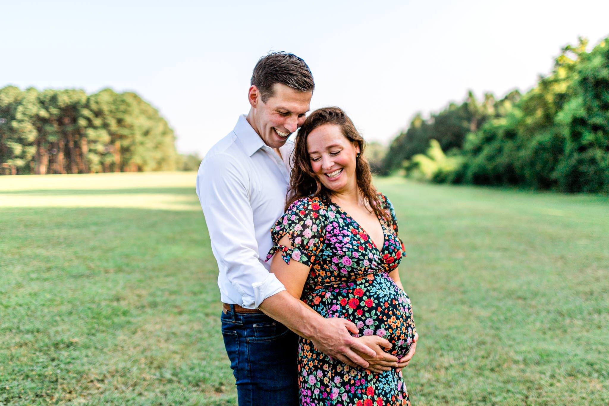 Raleigh Maternity Photographer | Dix Park | By G. Lin Photography | Couple standing in open field and smiling