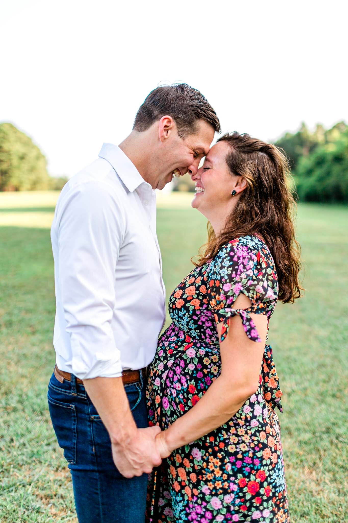 Raleigh Maternity Photographer | Dix Park | By G. Lin Photography | Couple holding hands and leaning against one another