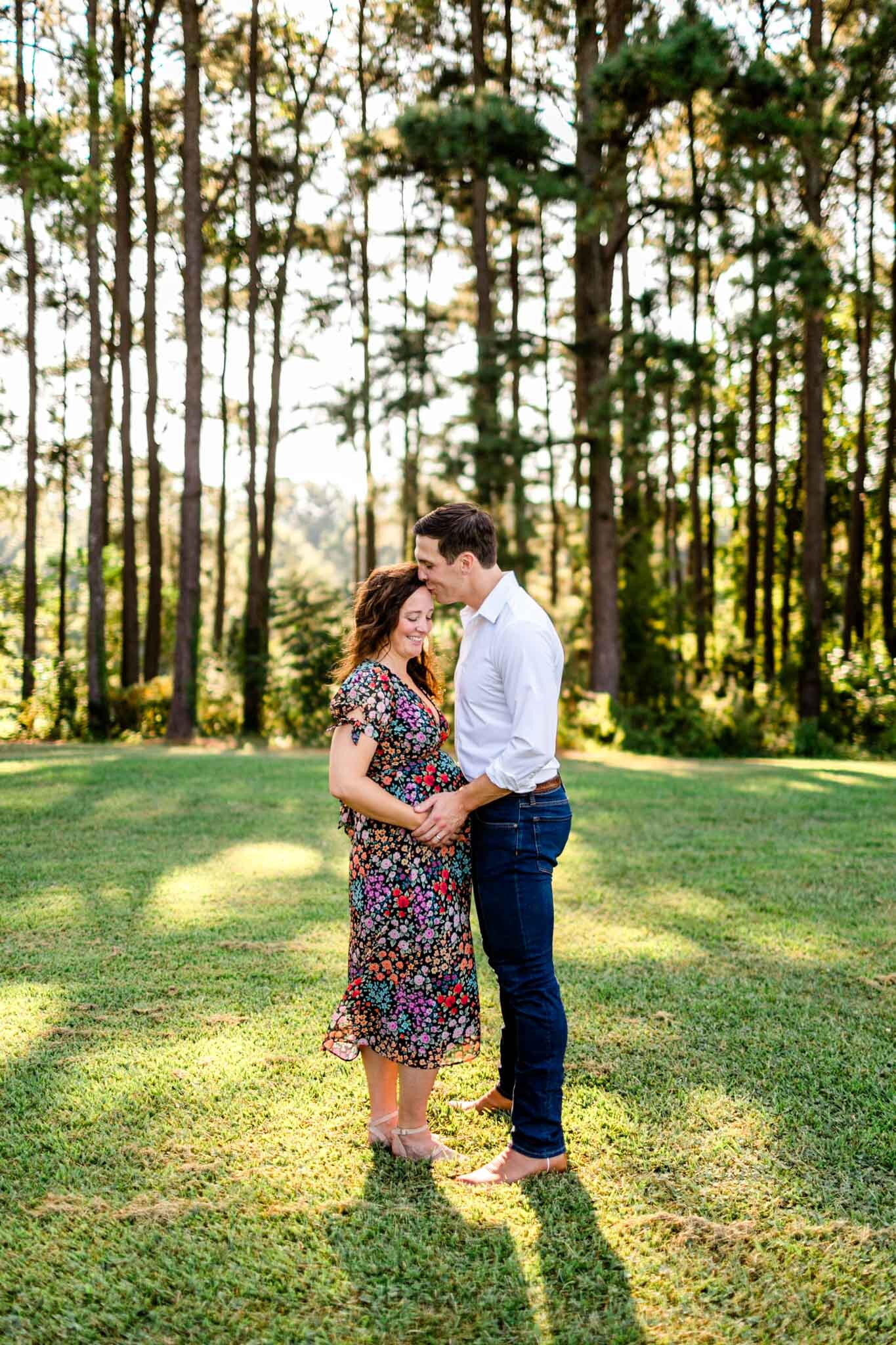 Raleigh Maternity Photographer | Dix Park | By G. Lin Photography | Beautiful portrait of husband and pregnant wife standing in front of trees