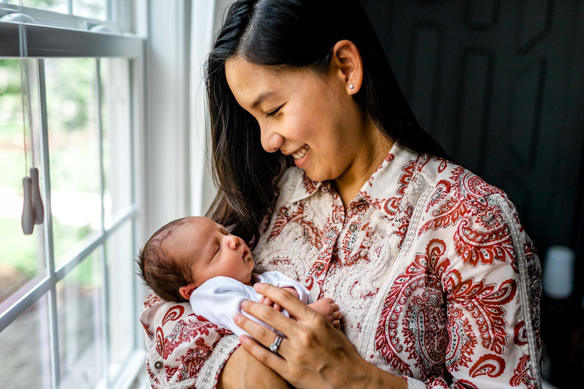 Pittsboro Newborn Photographer | By G. Lin Photography | Mother holding baby by the window