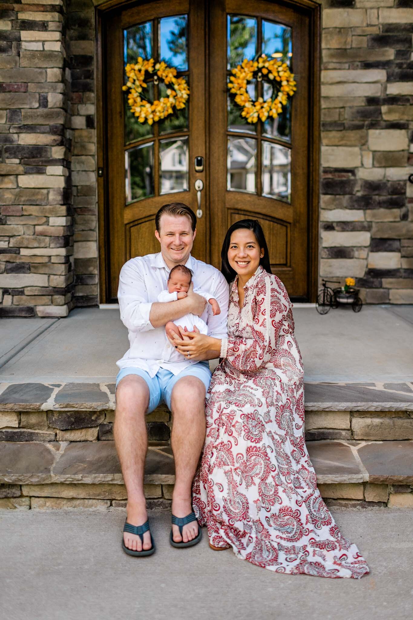 Pittsboro Newborn Photographer | By G. Lin Photography | Couple sitting on front porch with baby