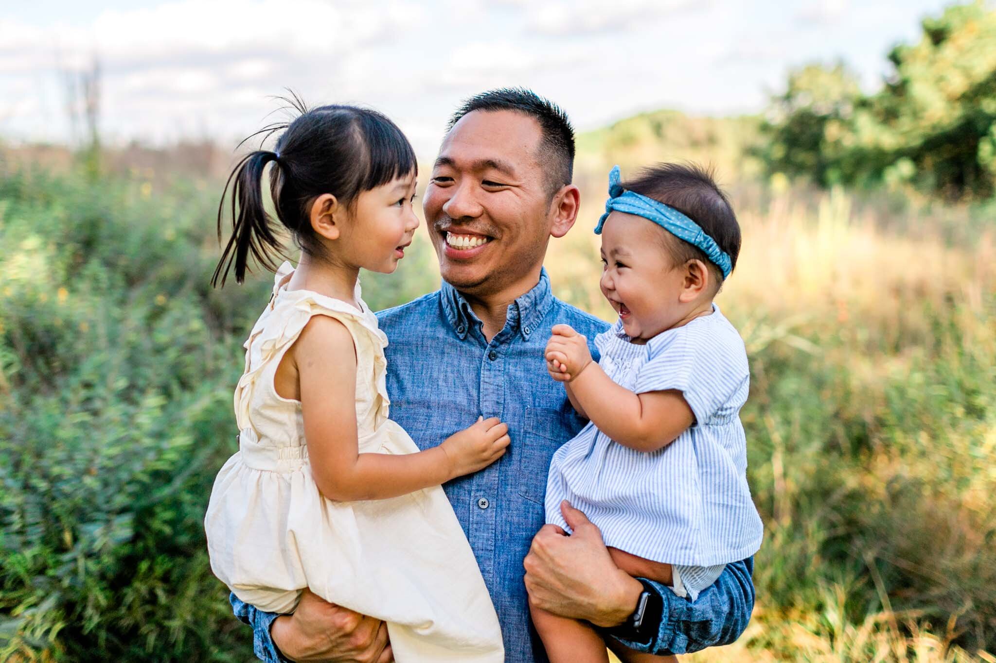Raleigh Family Photographer | By G. Lin Photography | Father laughing with daughters standing in open field