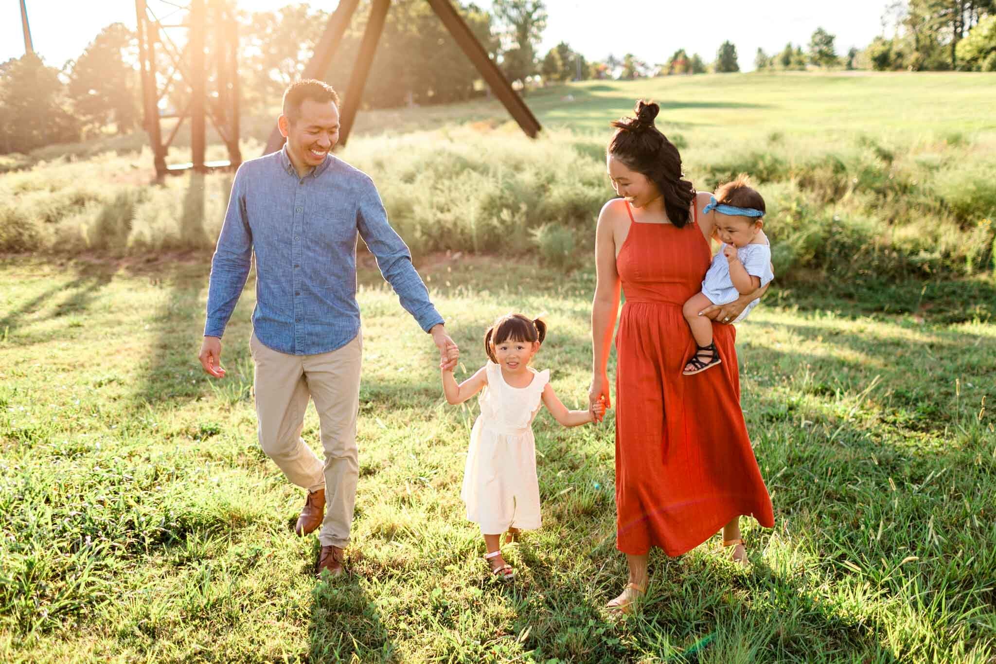 Raleigh Family Photographer | By G. Lin Photography | Candid open field photo of family walking together and holding hands