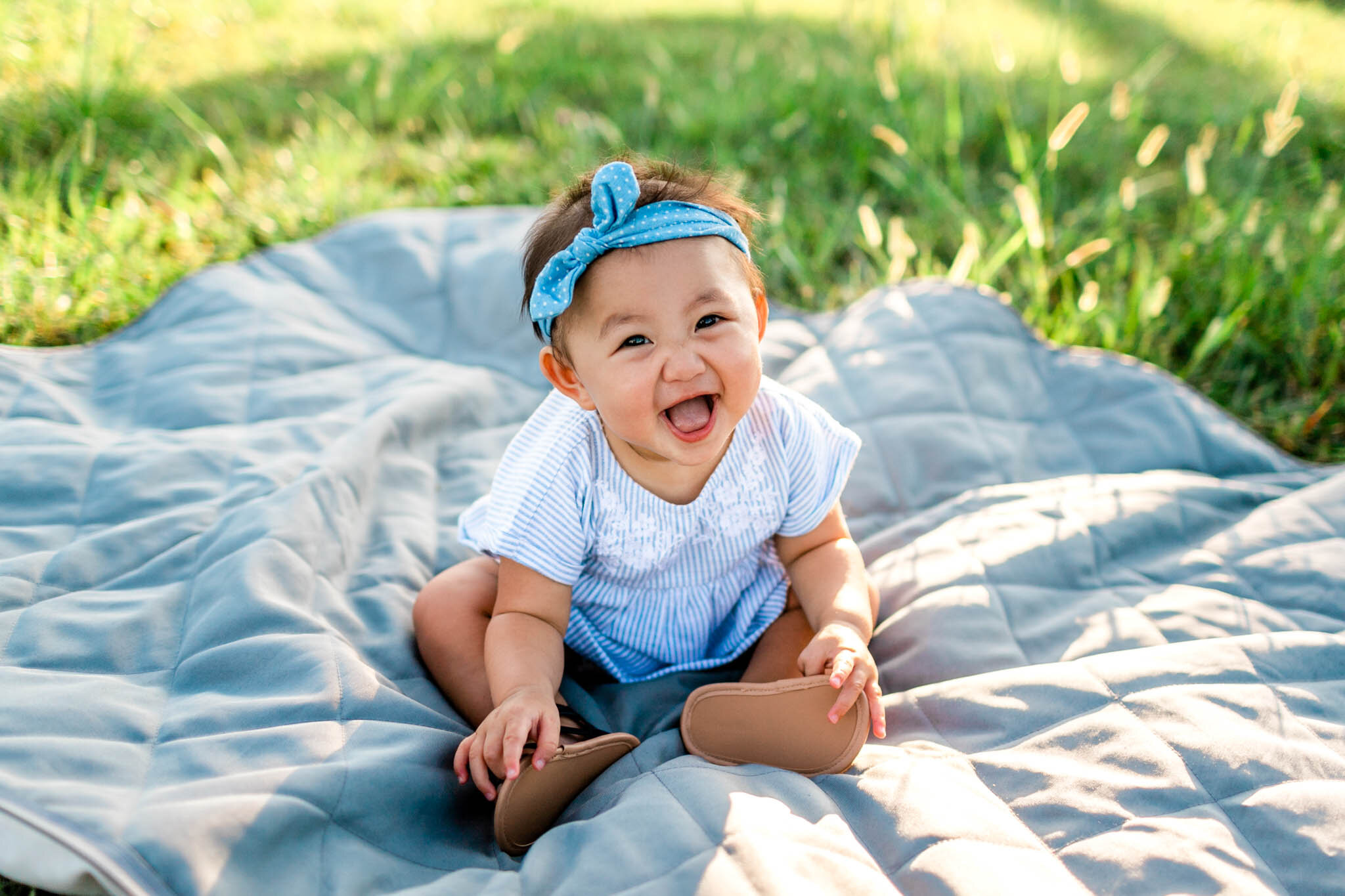 Raleigh Family Photographer | By G. Lin Photography | Baby girl smiling at camera and sitting on blanket