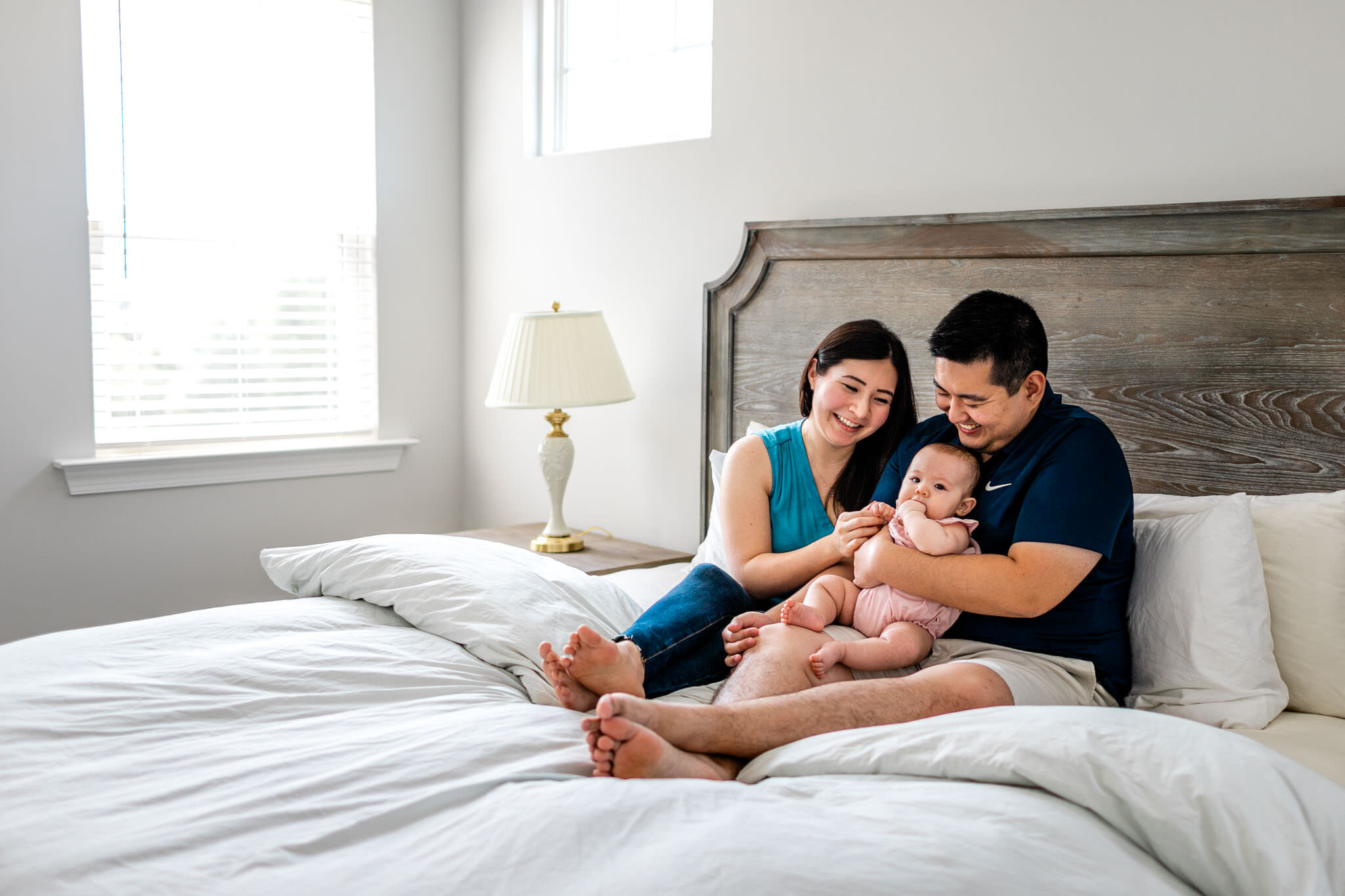 Raleigh Family Photographer | By G. Lin Photography | Parents sitting on bed with baby girl