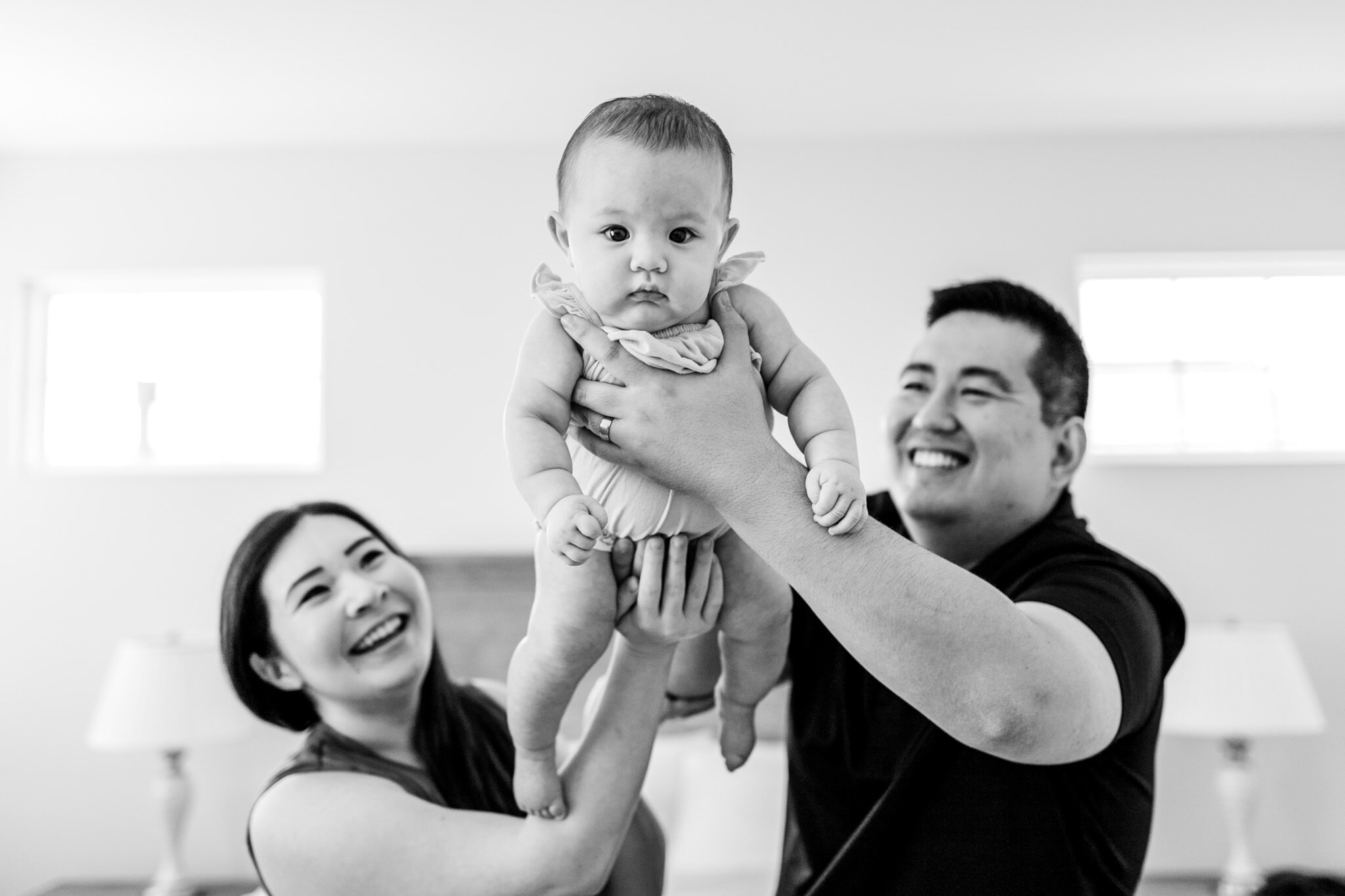 Raleigh Family Photographer | By G. Lin Photography | Black and white photo of mom and dad lifting baby girl in the air