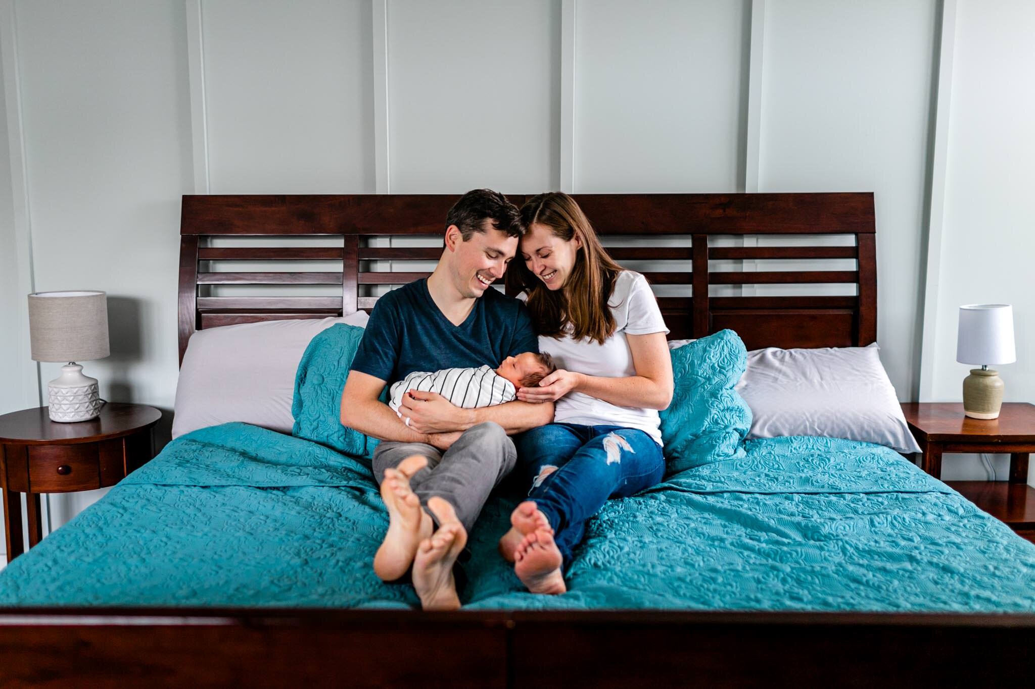 Durham Newborn Photographer | By G. Lin Photography | Father and mother holding baby on bed