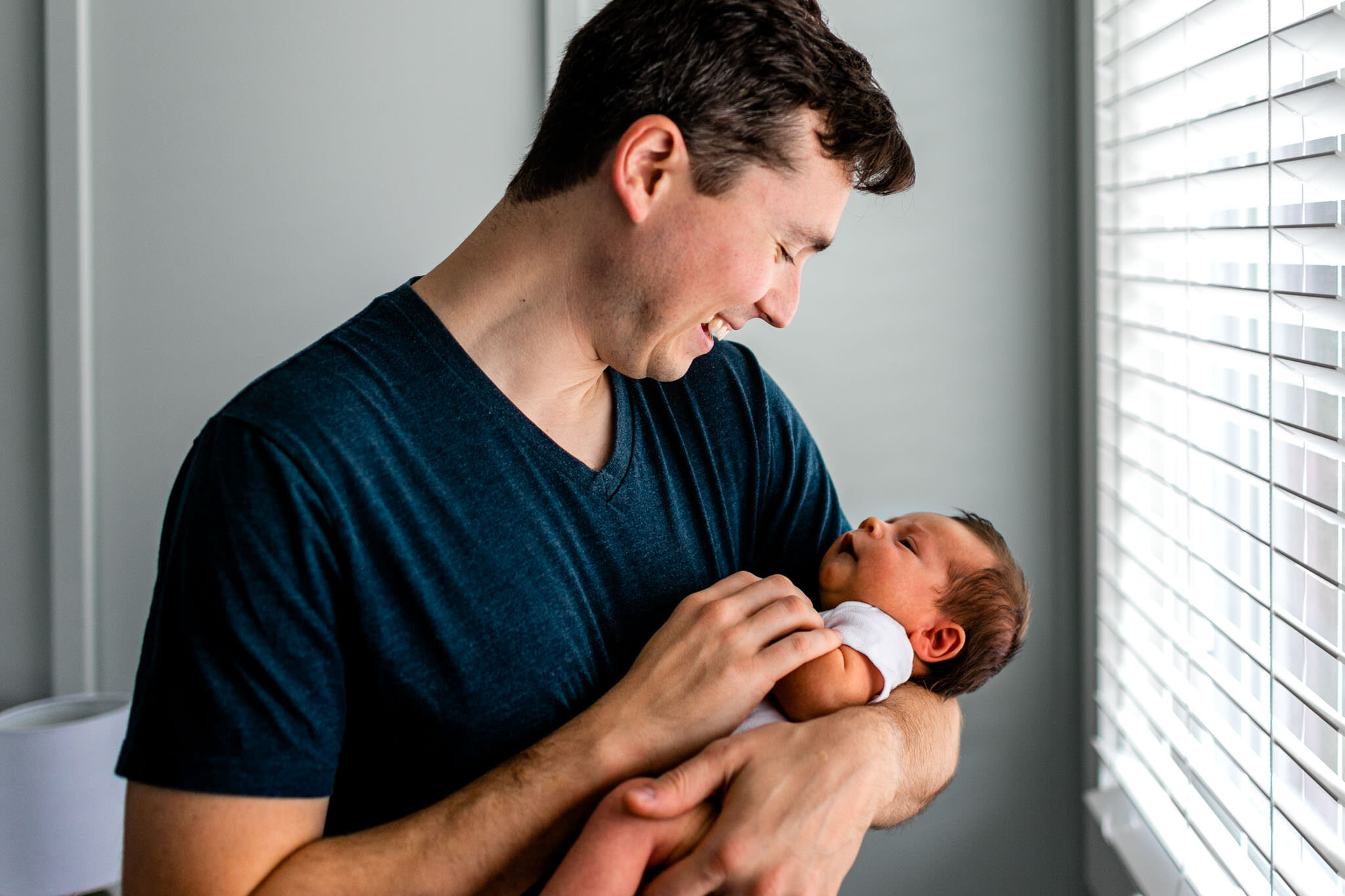 Durham Newborn Photographer | By G. Lin Photography | Father holding baby boy by the window