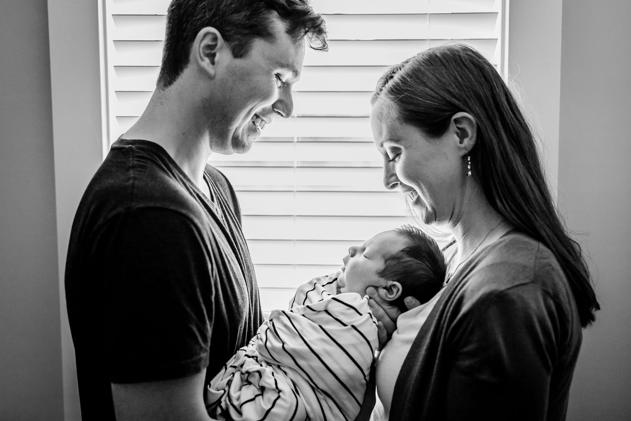 Durham Newborn Photographer | By G. Lin Photography | Parents holding baby next to window