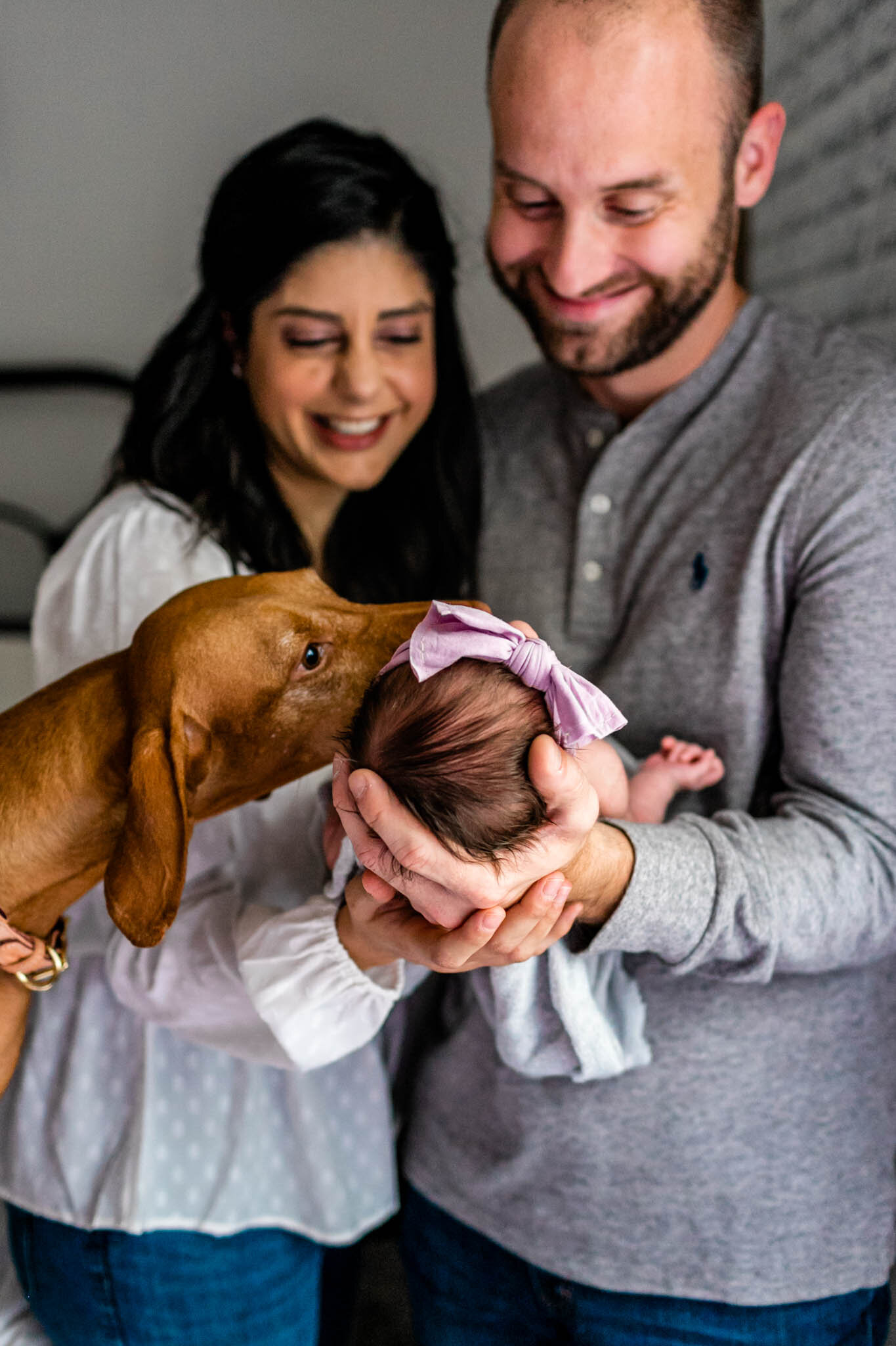 Charlotte Newborn Photographer | By G. Lin Photography | Couple holding baby with dog sniffing baby