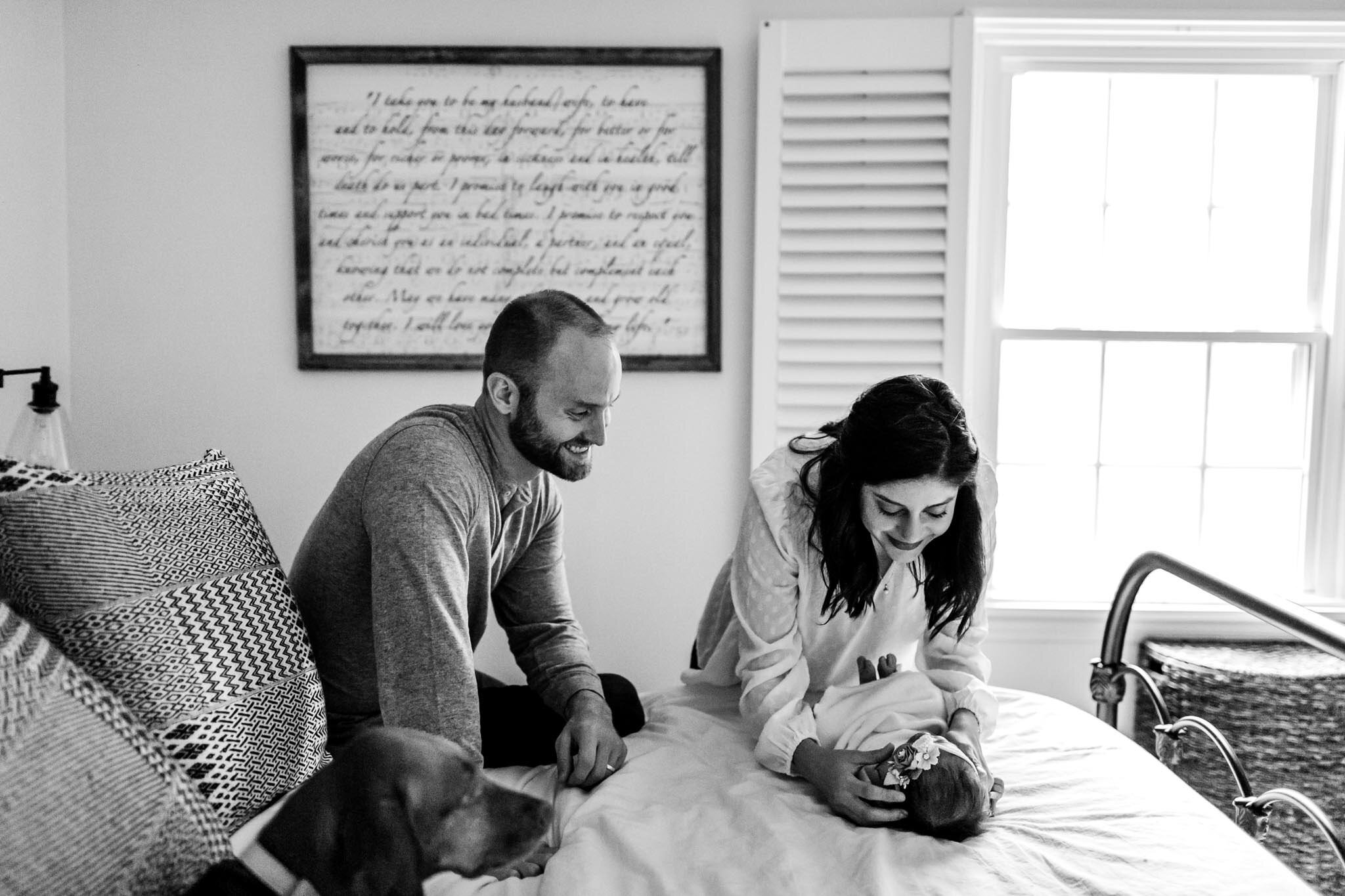 Charlotte Newborn Photographer | By G. Lin Photography | Mother swaddling baby on bed