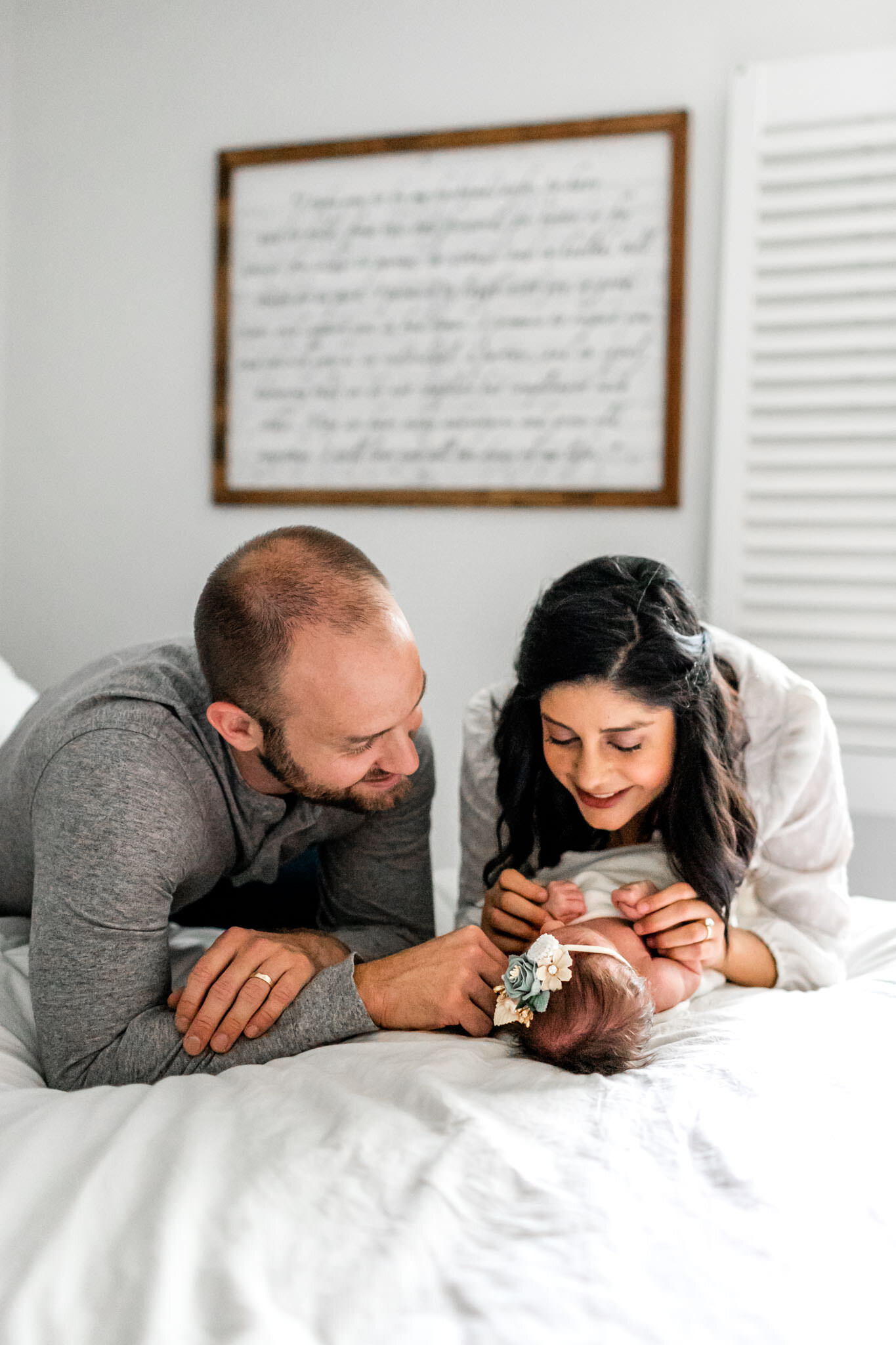 Charlotte Newborn Photographer | By G. Lin Photography | Man and woman looking at baby on bed