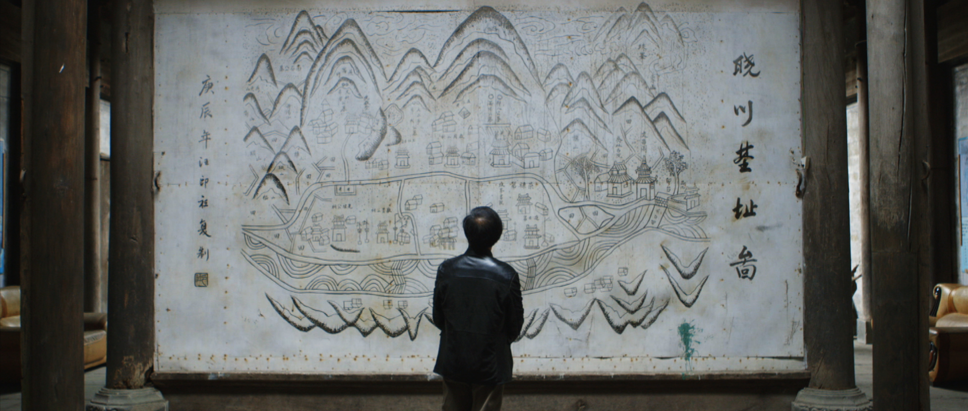 The president in front of the village's map.