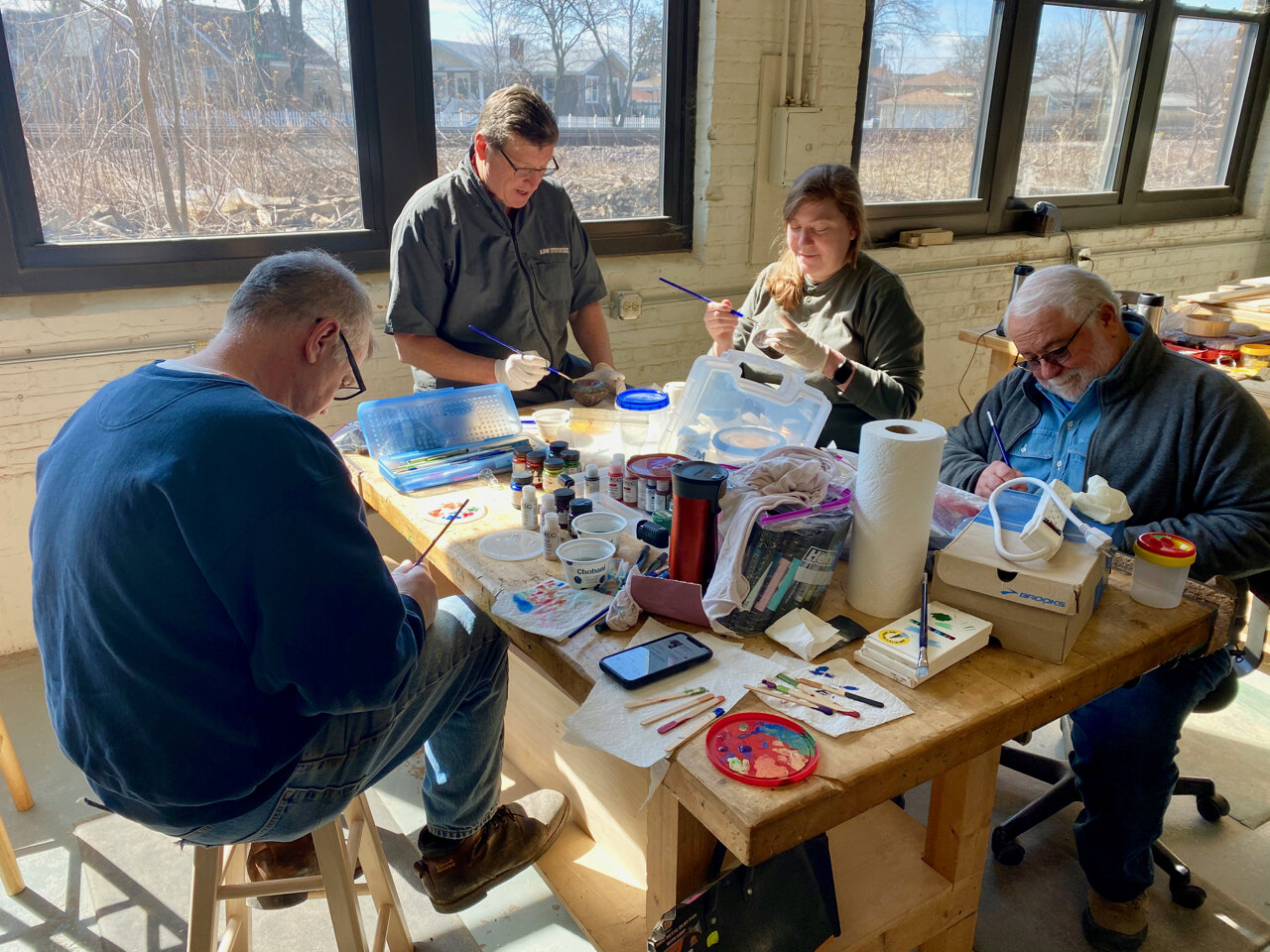  Surface enhancement techniques covered included pyrography, carving and texturing, and coloring. In this image, students are applying acrylic paint to their turnings. 