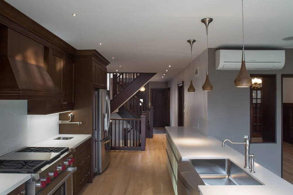 Modern kitchen wood cabinets, steel appliances, gas stove.