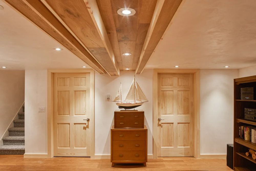 Basement two wooden doors, wood floor, white plaster floor and ceiling with LED potlights