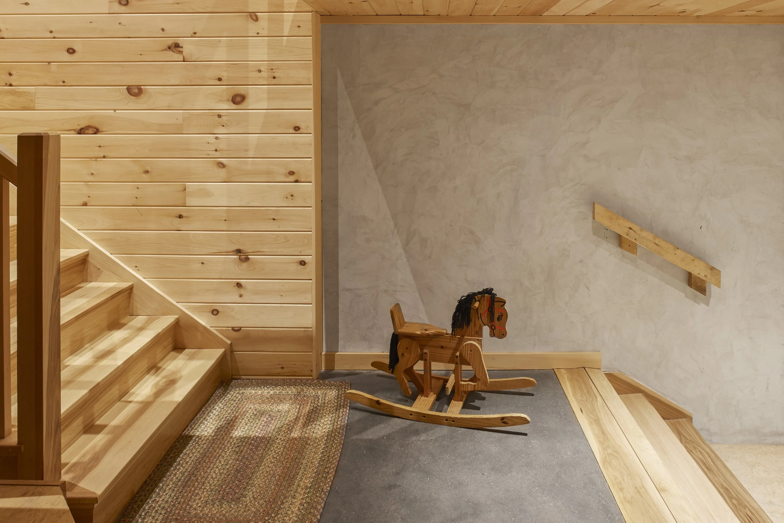 Stairway landing with wood steps, plaster and wood wall, toy