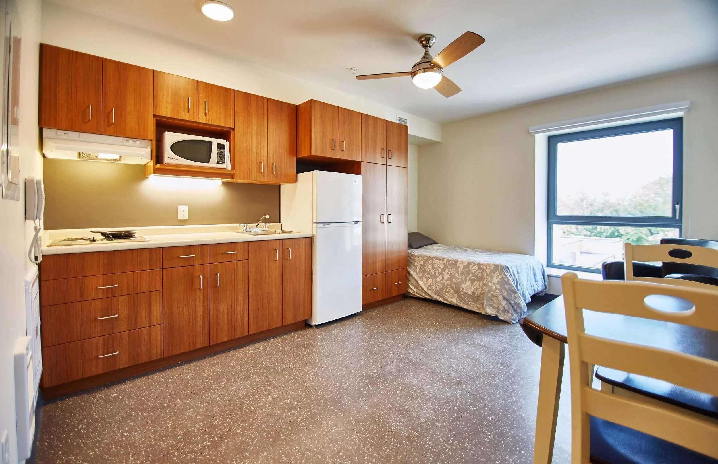 Open concept ground floor kitchen and living room. wood floor, wood cabinets, steel appliances, lime plaster walls.