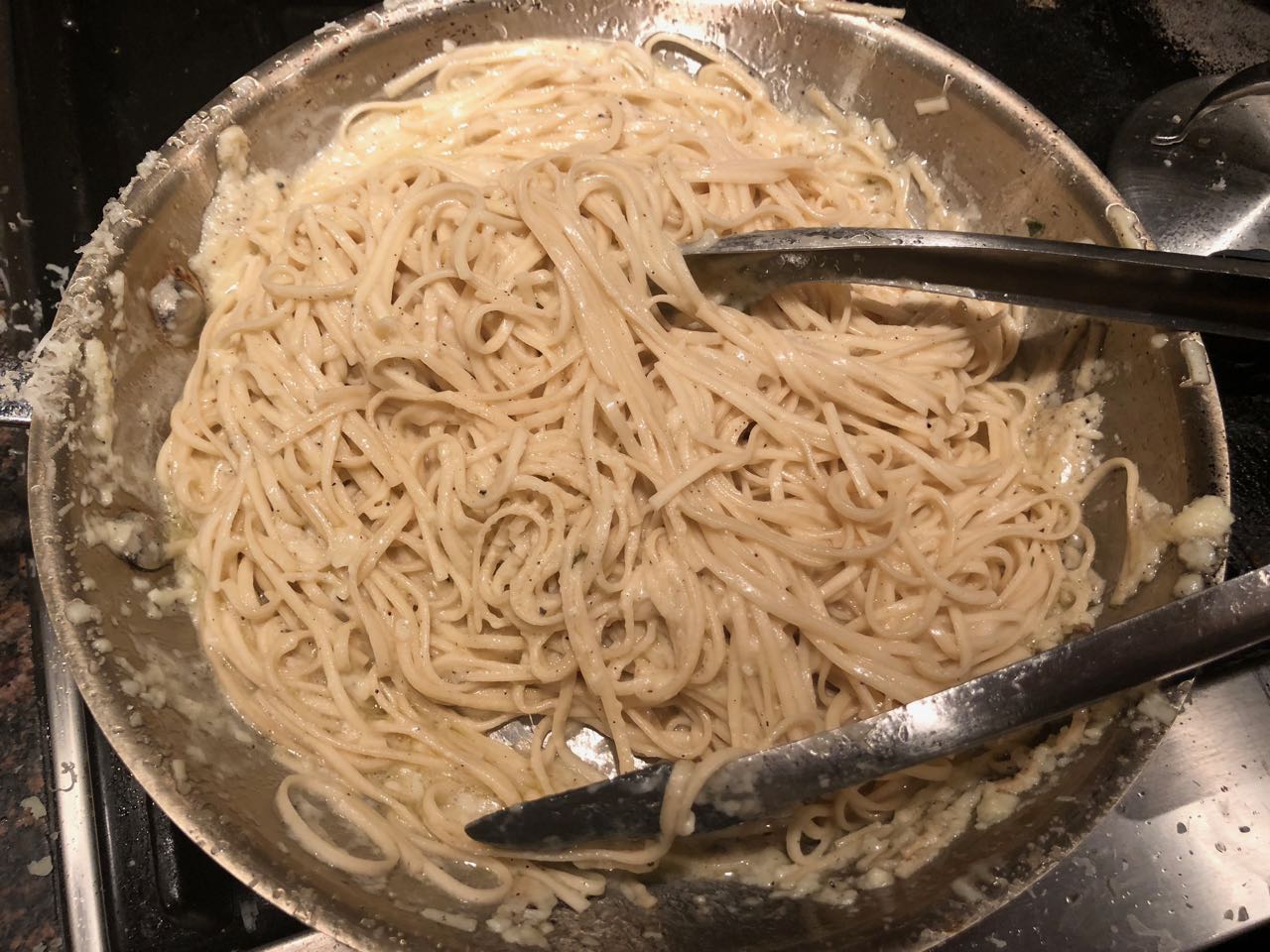 combining the romano and pasta in the skillet with oil and spices