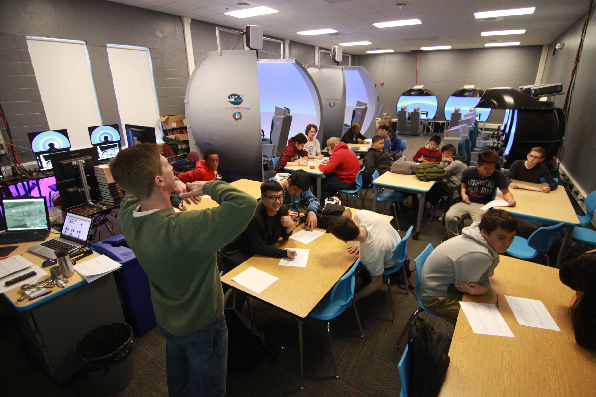 Teacher Scott Shaffer & students in the Flight Simulation Lab.