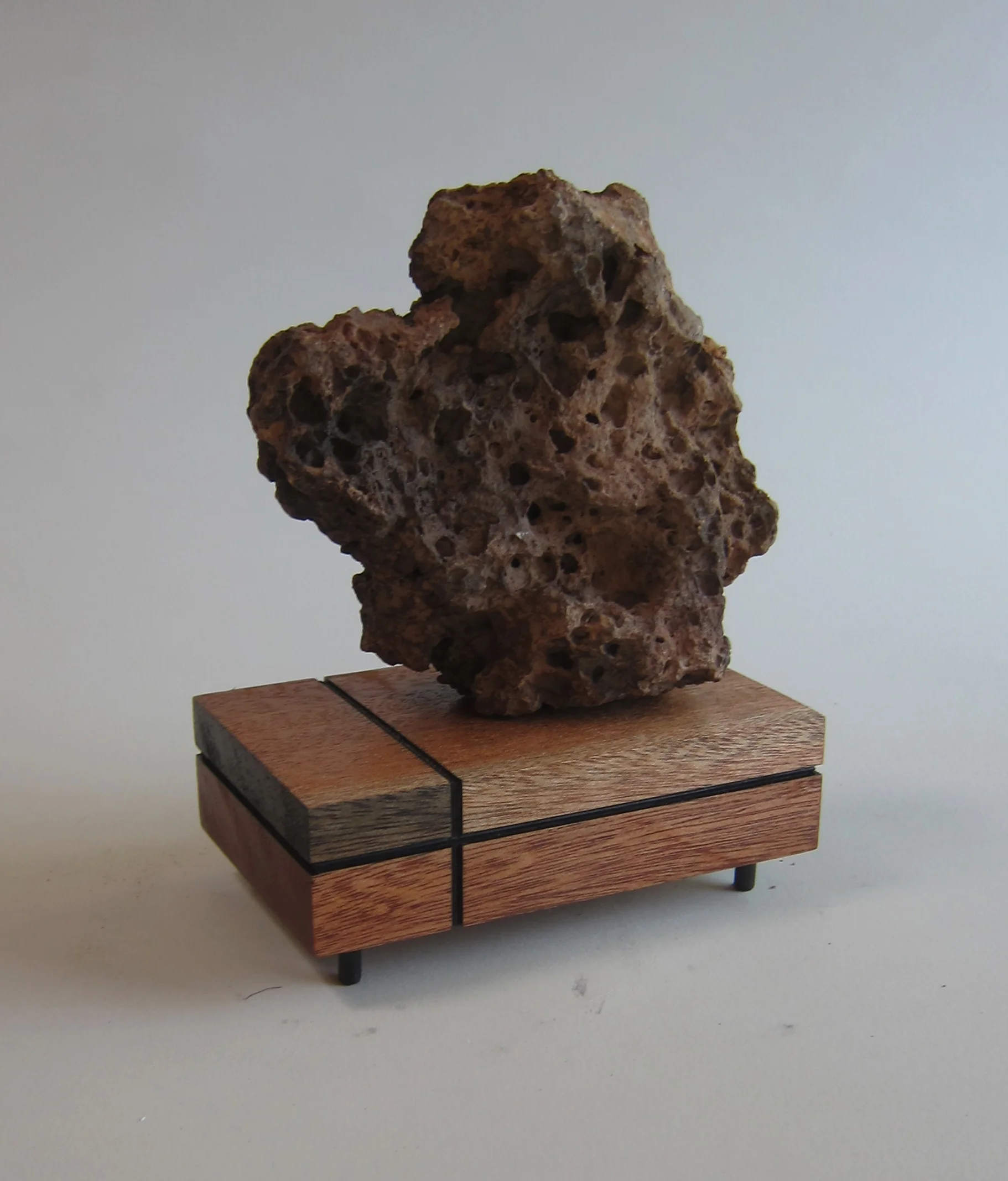   Volcanic rock, wood, painted aluminum.  