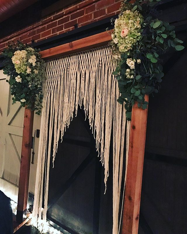 How dreamy is this macram&eacute; hanging from an arch built by the groom's best man and father and surrounded by @flowerno5's arrangement? It was used both for the ceremony and then transitioned as a backdrop for the sweetheart table during the rece